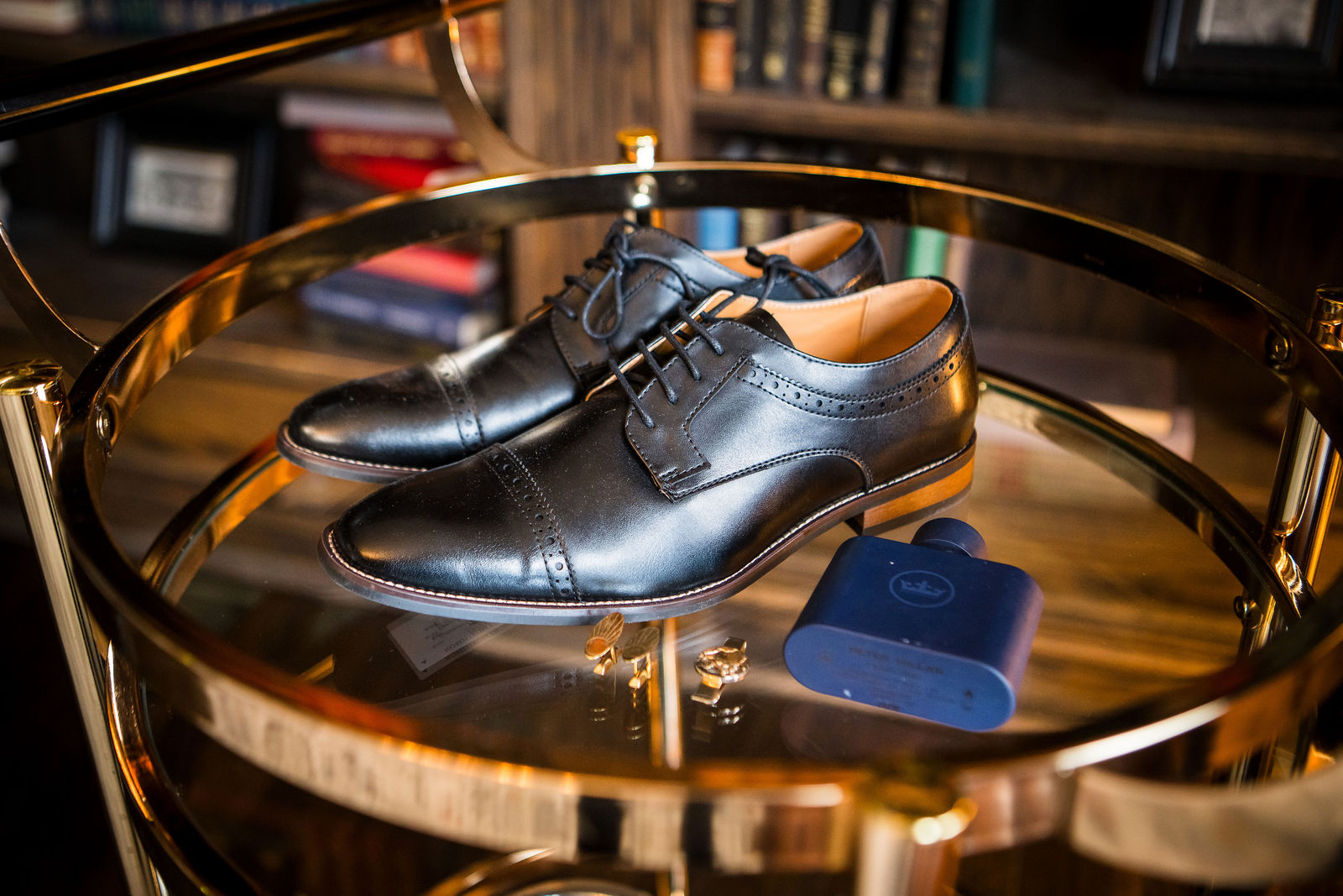 Groom’s dress shoes, watch and wedding bands laid out before a Manor House wedding
