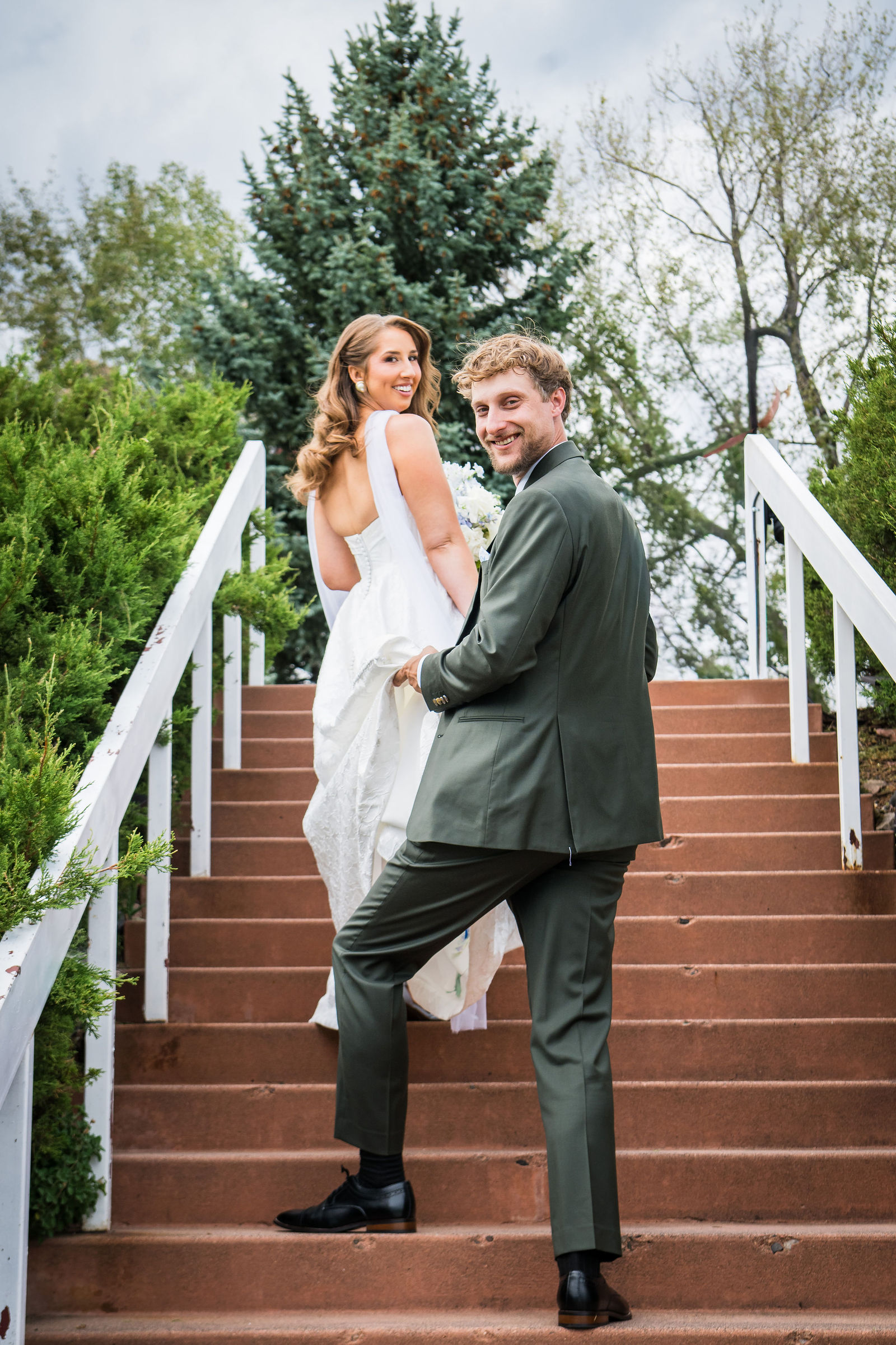 Bride and groom on the white staircase at the Manor House