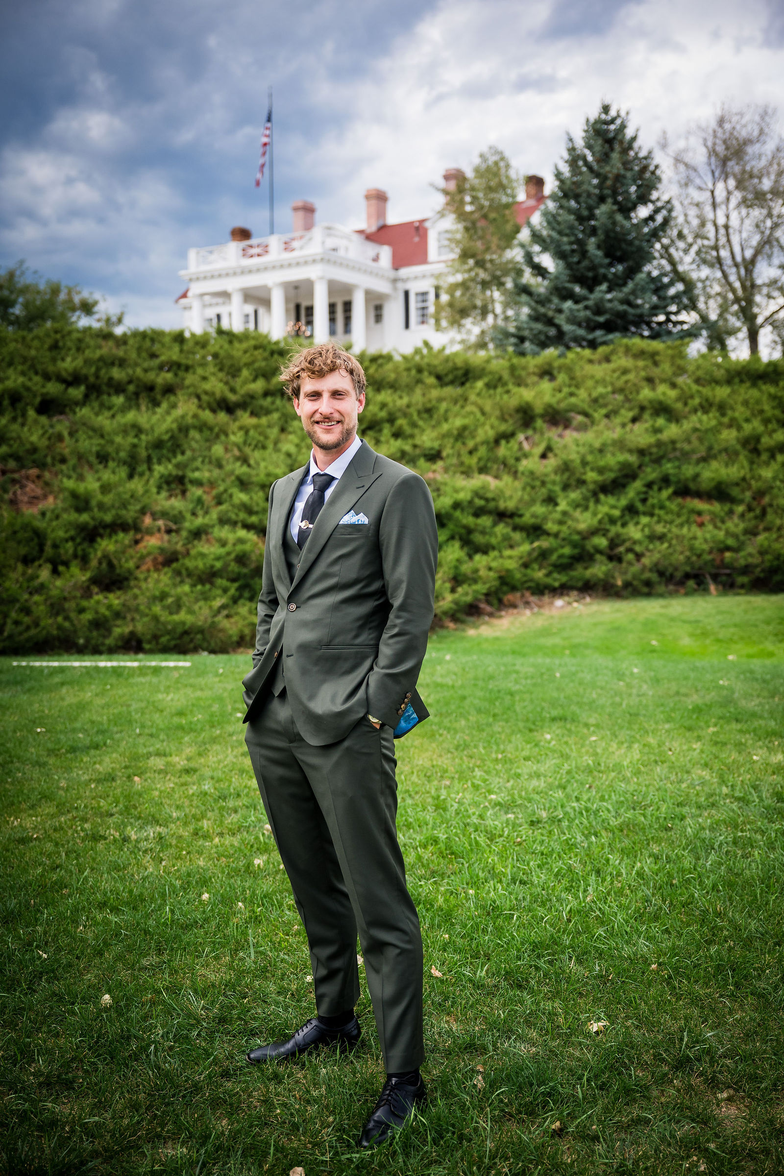 Groom portrait in an olive green suit at the Manor House
