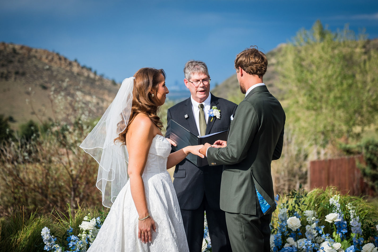 Bride and groom exchanging rings at a Manor House wedding