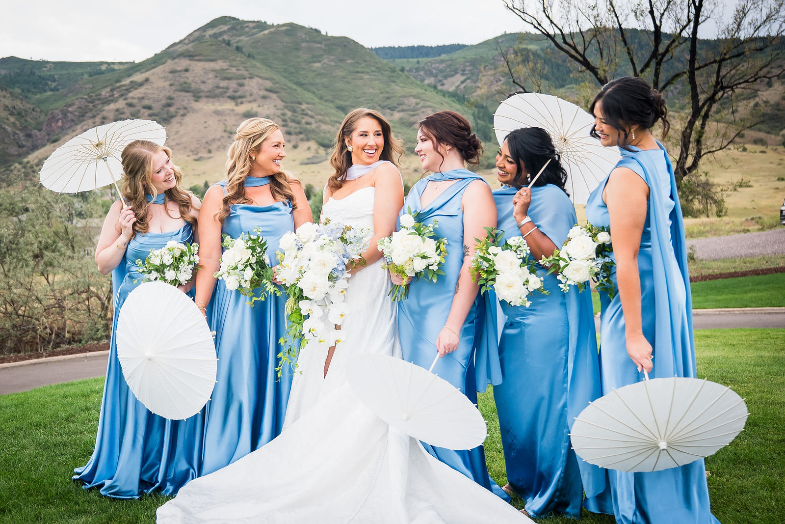 Bridesmaids holding white parasols at a Littleton Colorado wedding