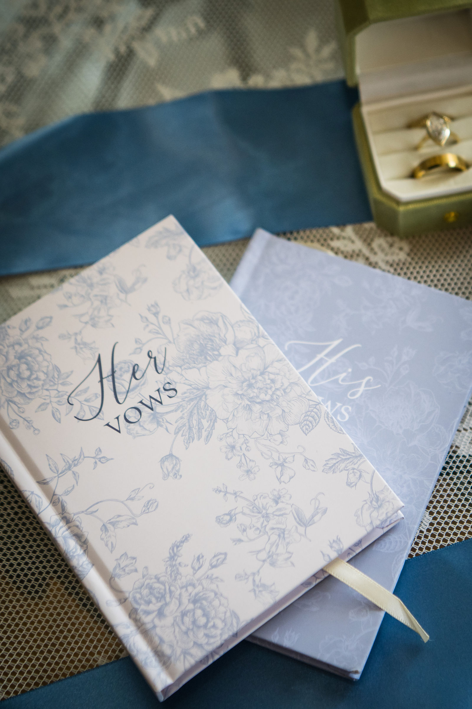 Two white vow books labeled Her Vows before a private vow exchange