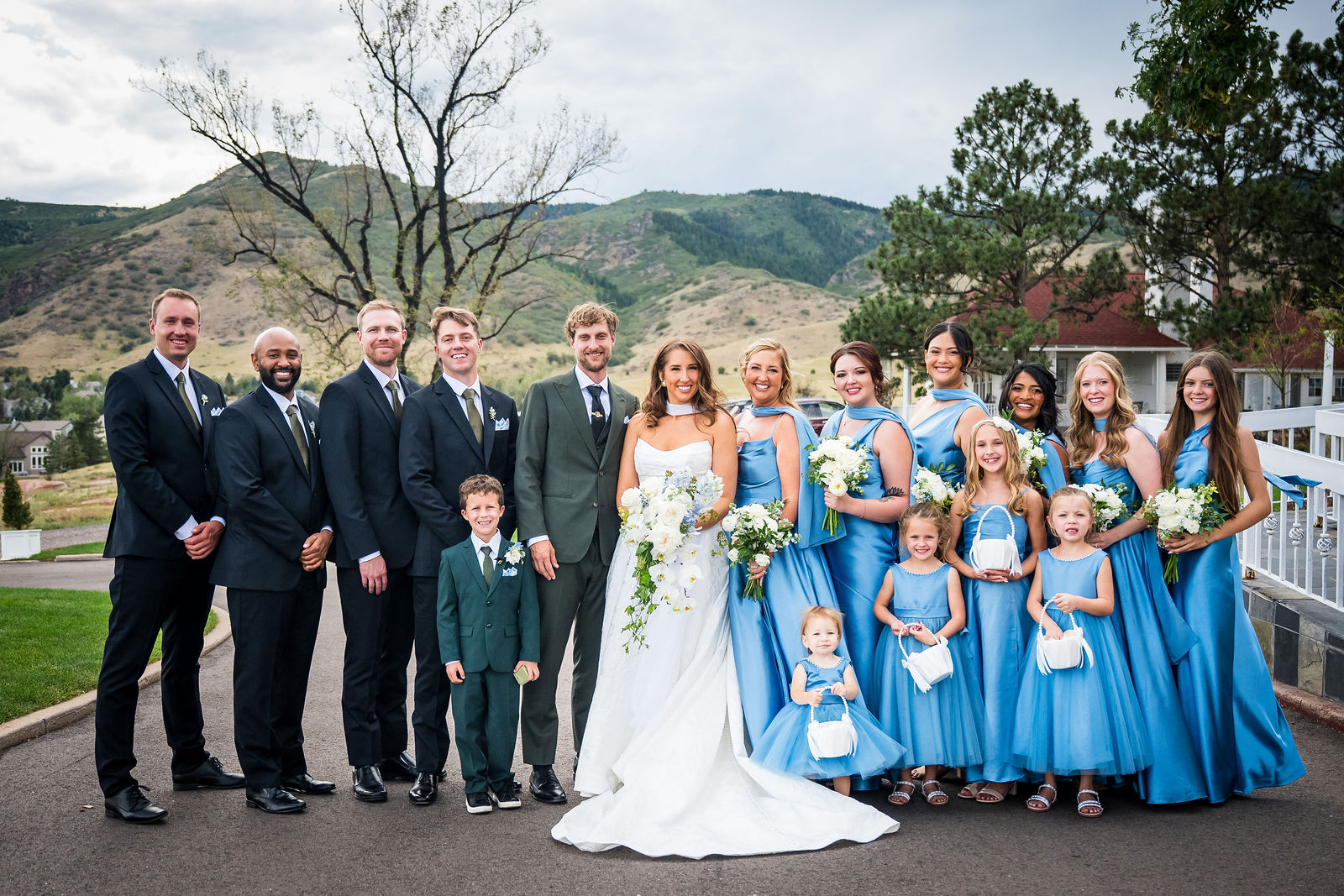Full wedding party with the Colorado foothills behind them at the Manor House