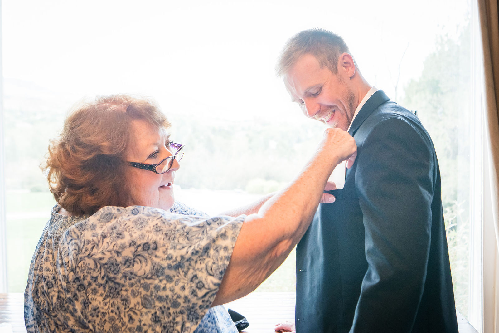 Mother of the groom fixing her son’s tie at a Manor House wedding
