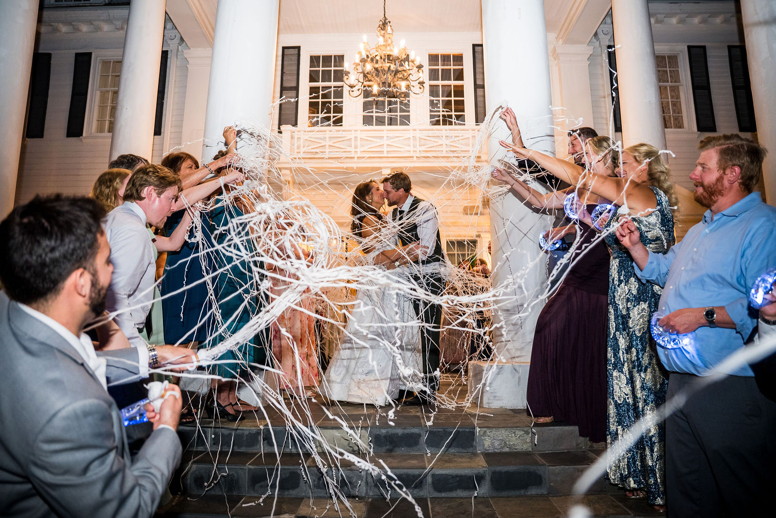 Bride and groom running through streamers at their Manor House exit