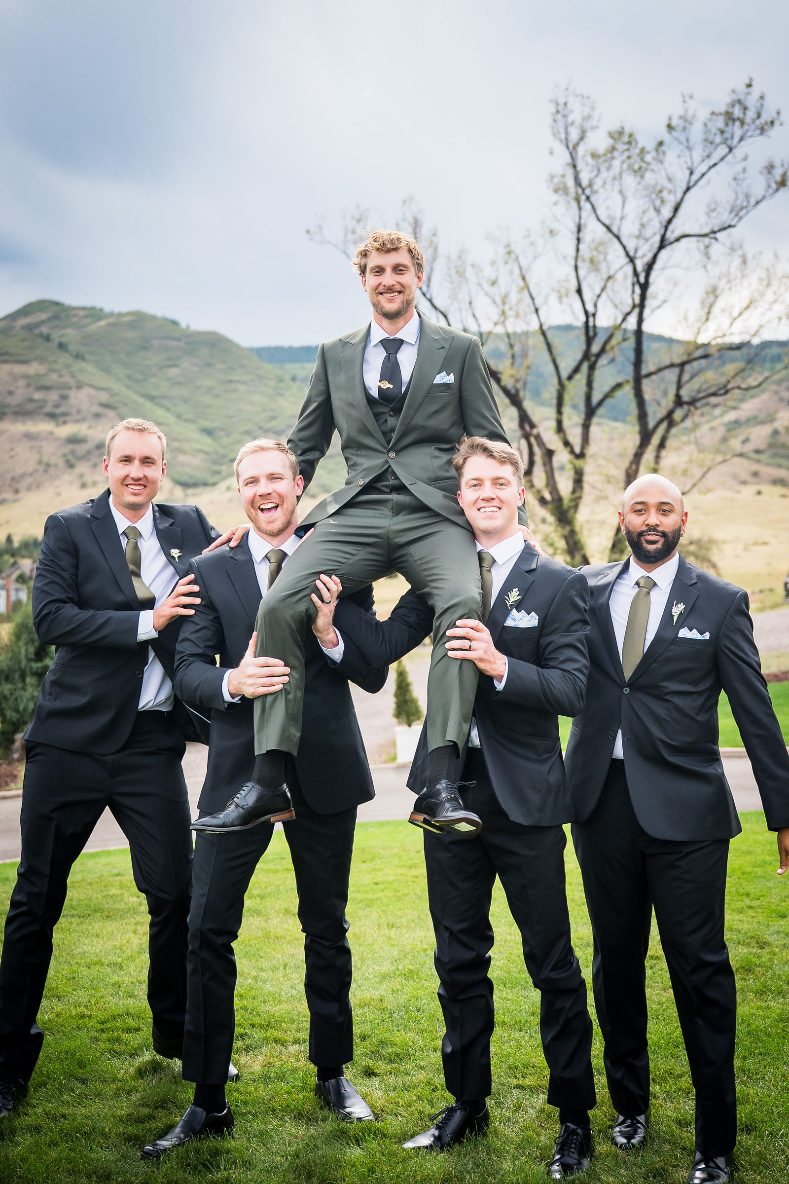 Groomsmen carrying the groom outside at a Manor House wedding