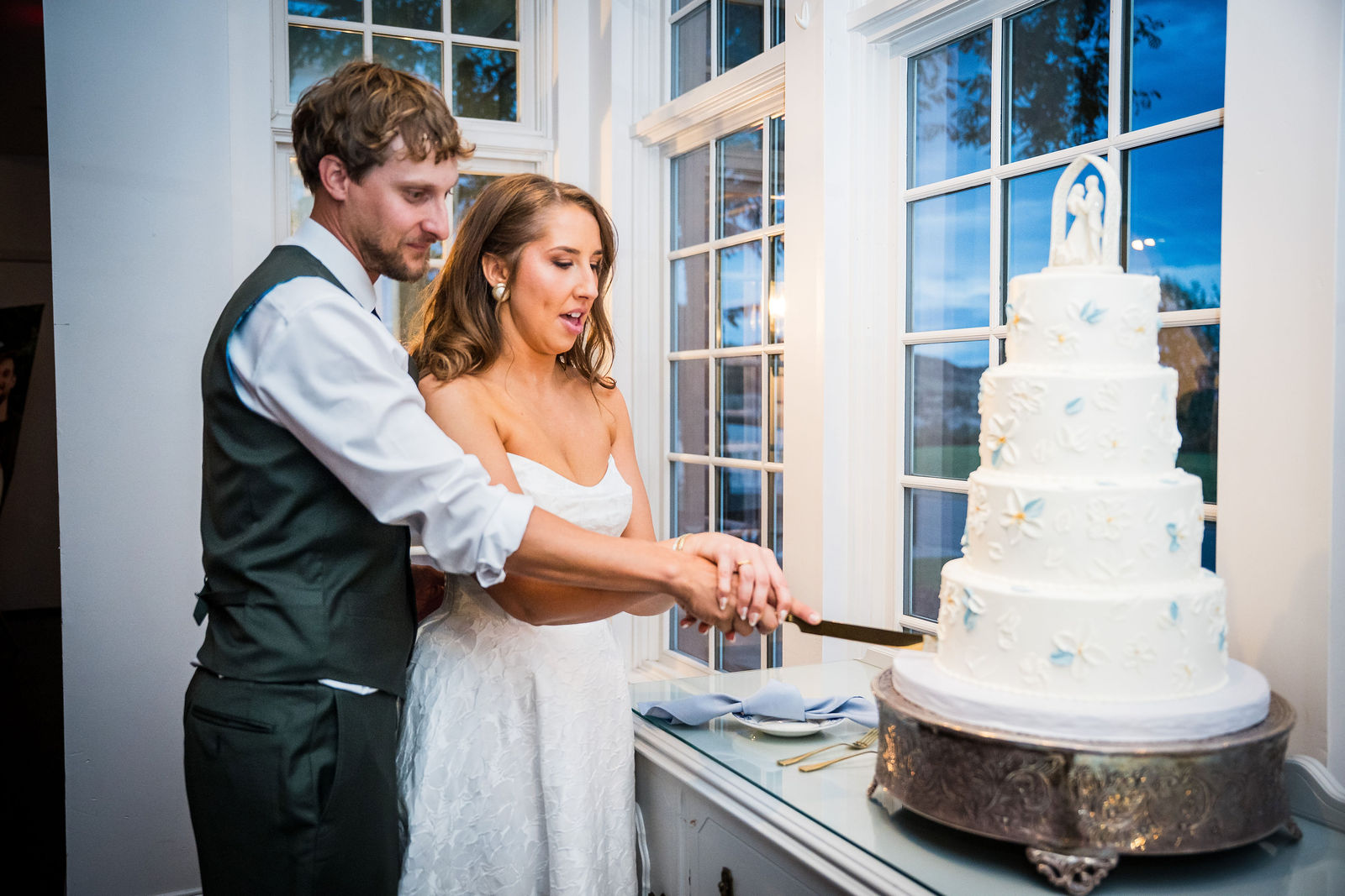 Bride and groom cutting their cake by The Makery at the Manor House