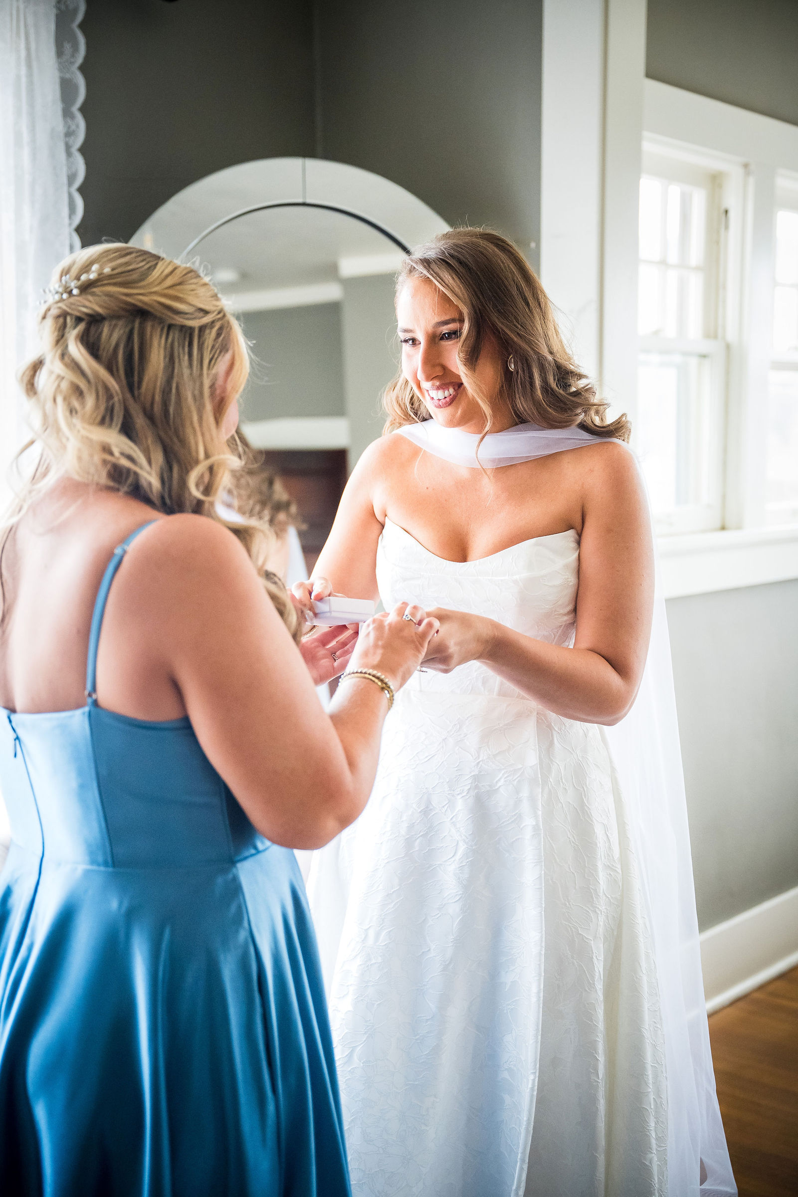 Bride giving her sister a ring engraved with their maiden names before the wedding
