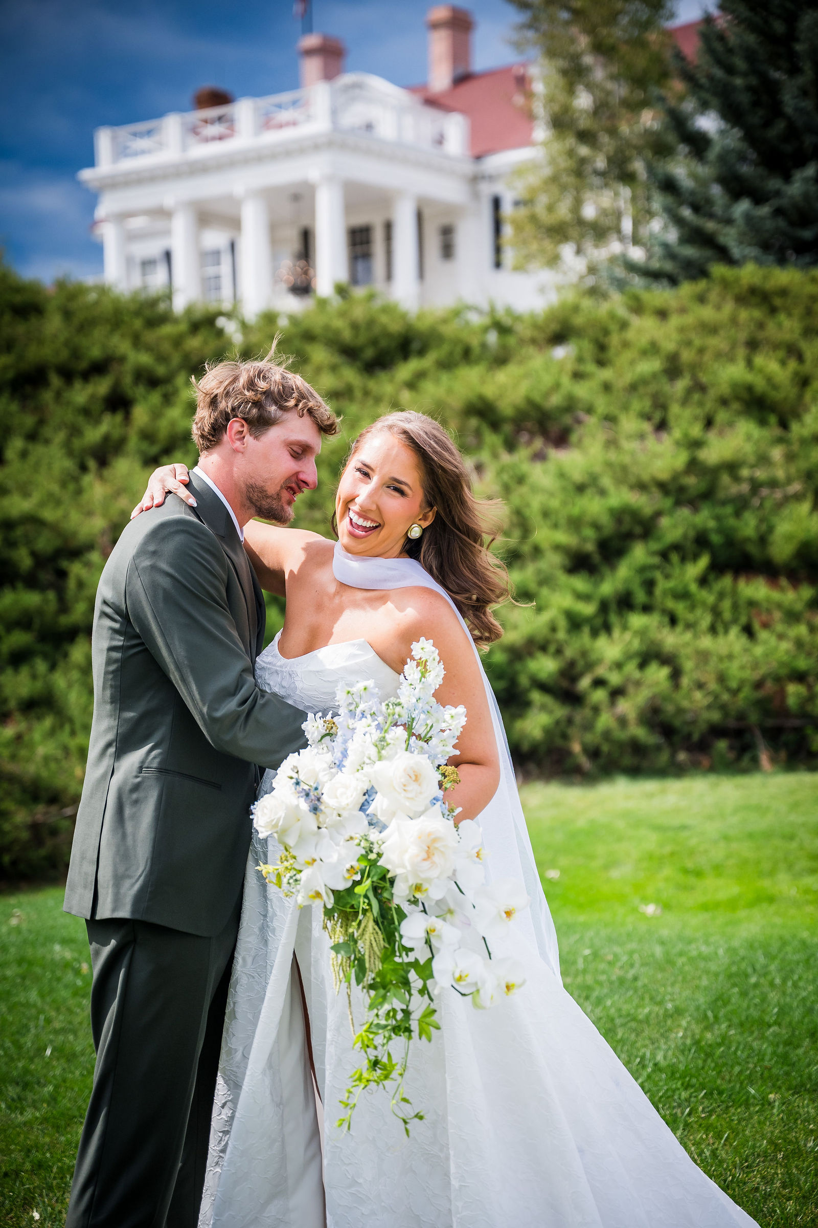 Bride and groom with her bouquet on the lawn at the Manor House