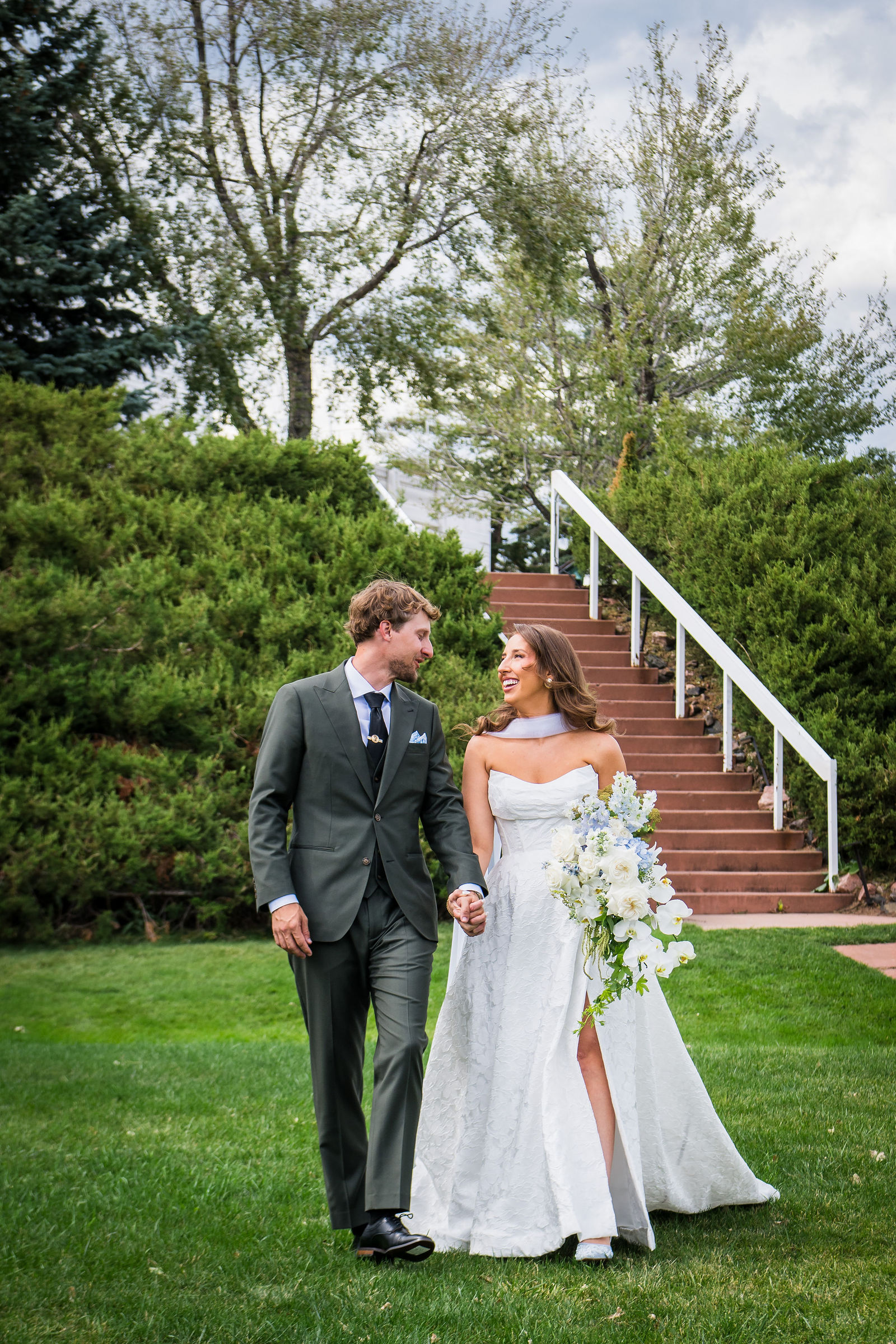 Couple walking down the white steps at the Manor House in Littleton Colorado