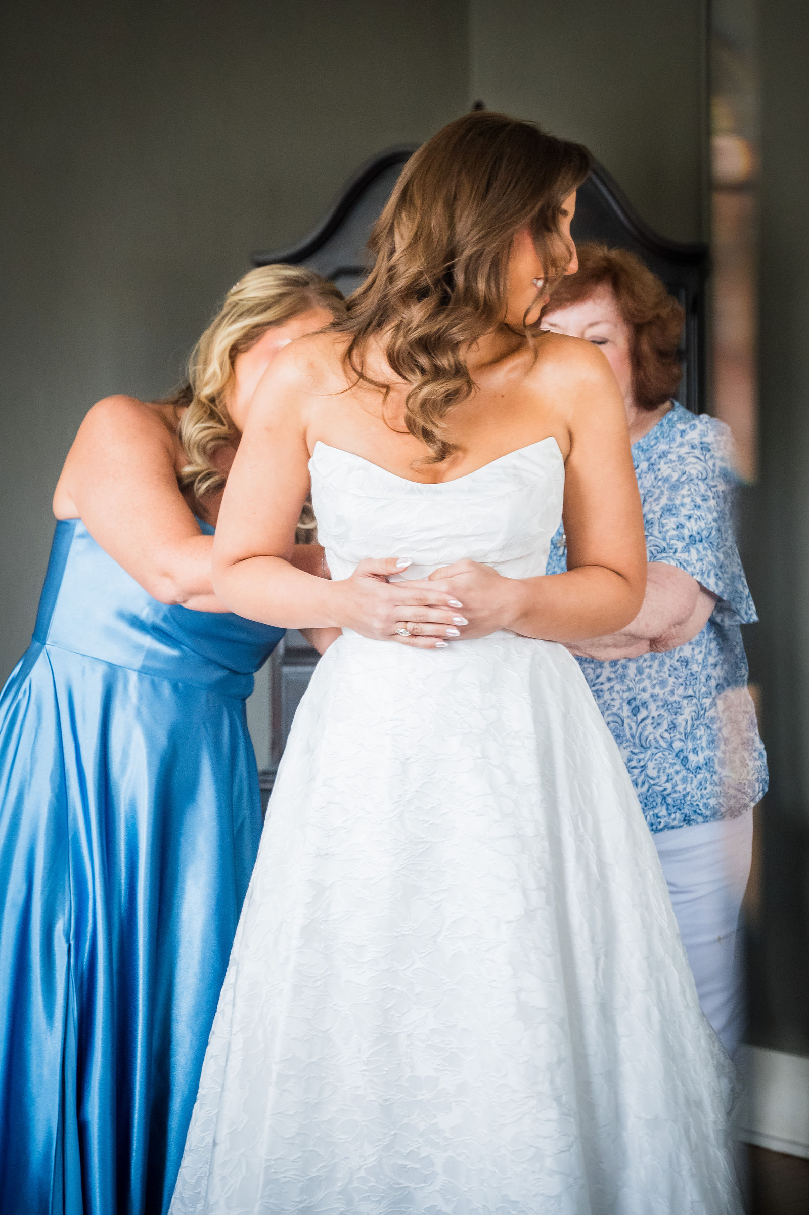Mother of the bride zipping her daughter’s wedding dress at the Manor House