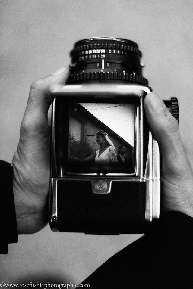 Un appareil photo ancien entre les mains, en noir et blanc