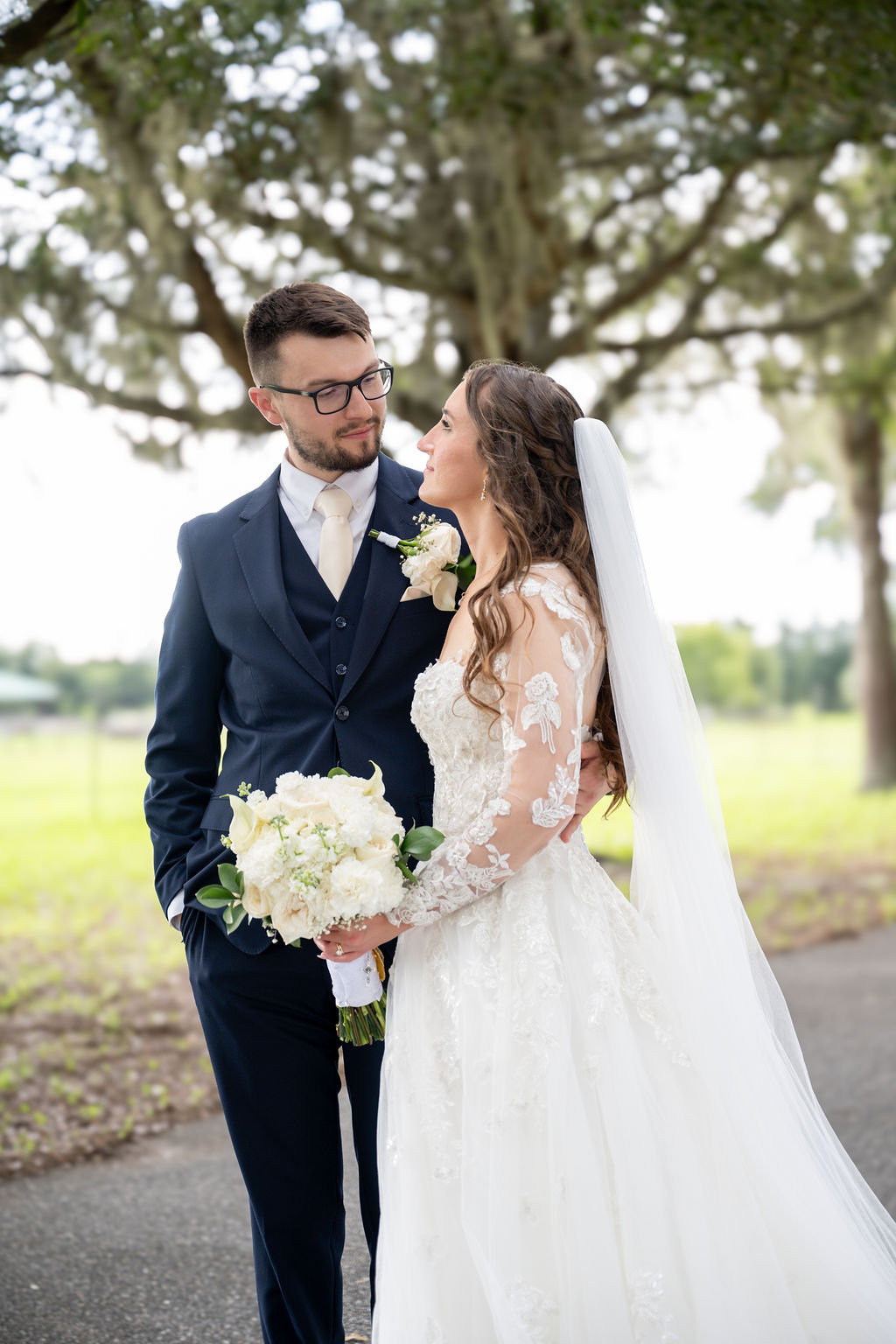 Bride and groom sharing an intimate portrait beneath an oak tree