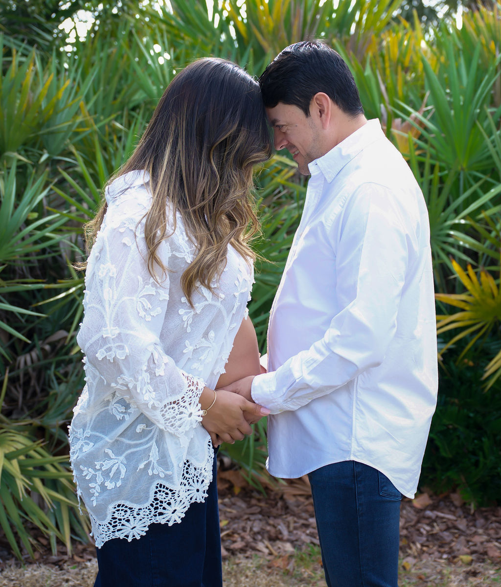 Expectant couple touching foreheads during an outdoor maternity session