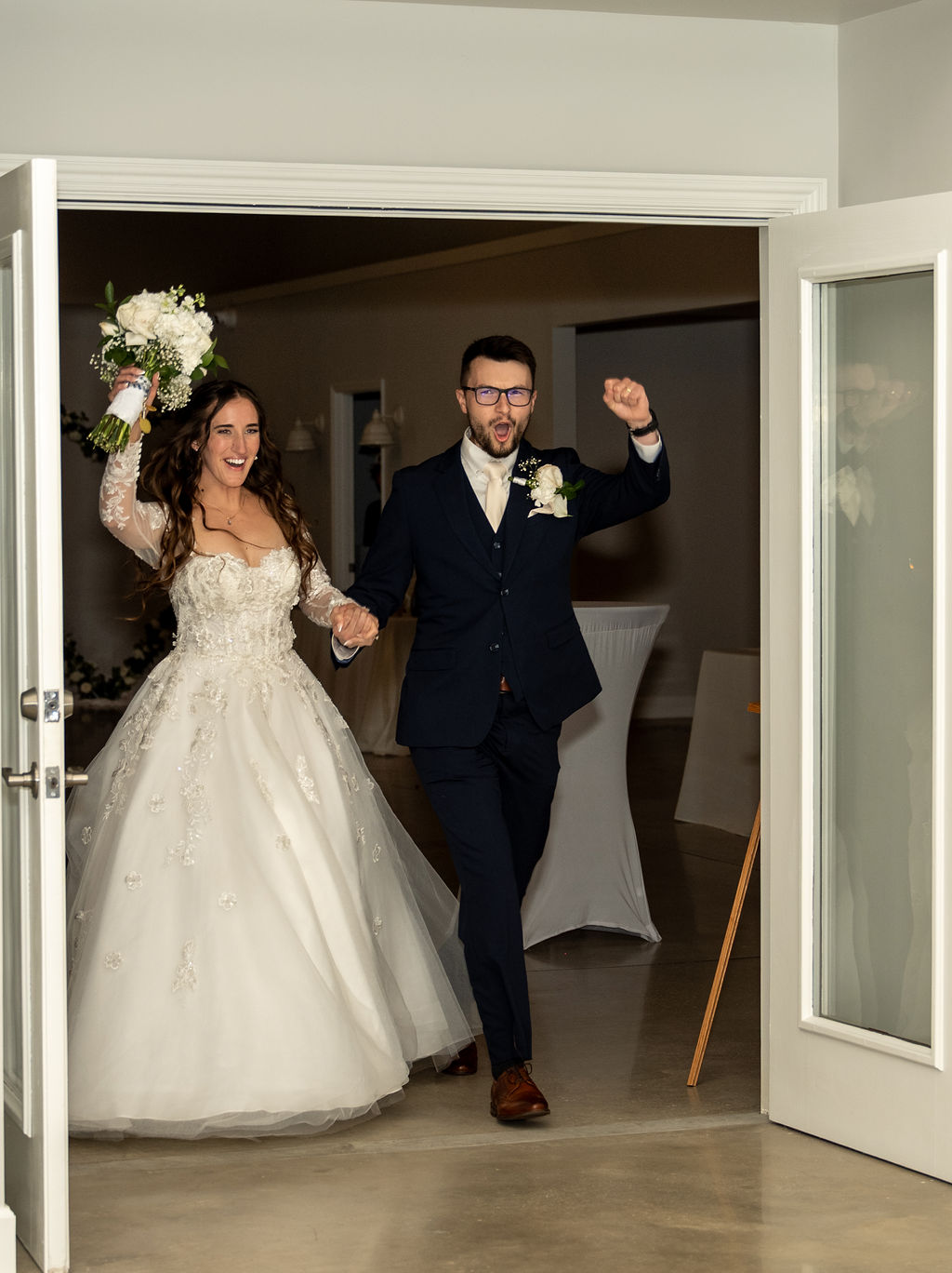 Newlyweds celebrating as they enter their wedding reception