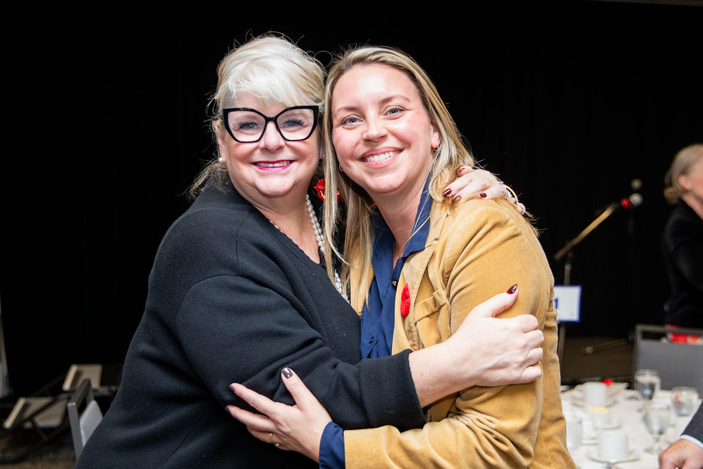 Two guests hugging hello