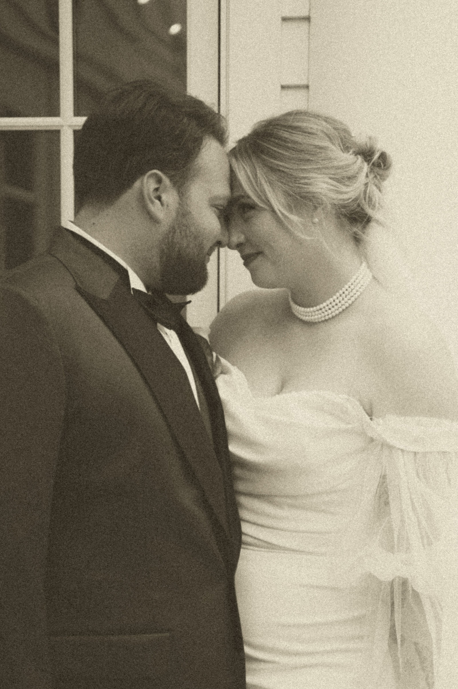 Bride and groom with foreheads touching in a warm vintage edit