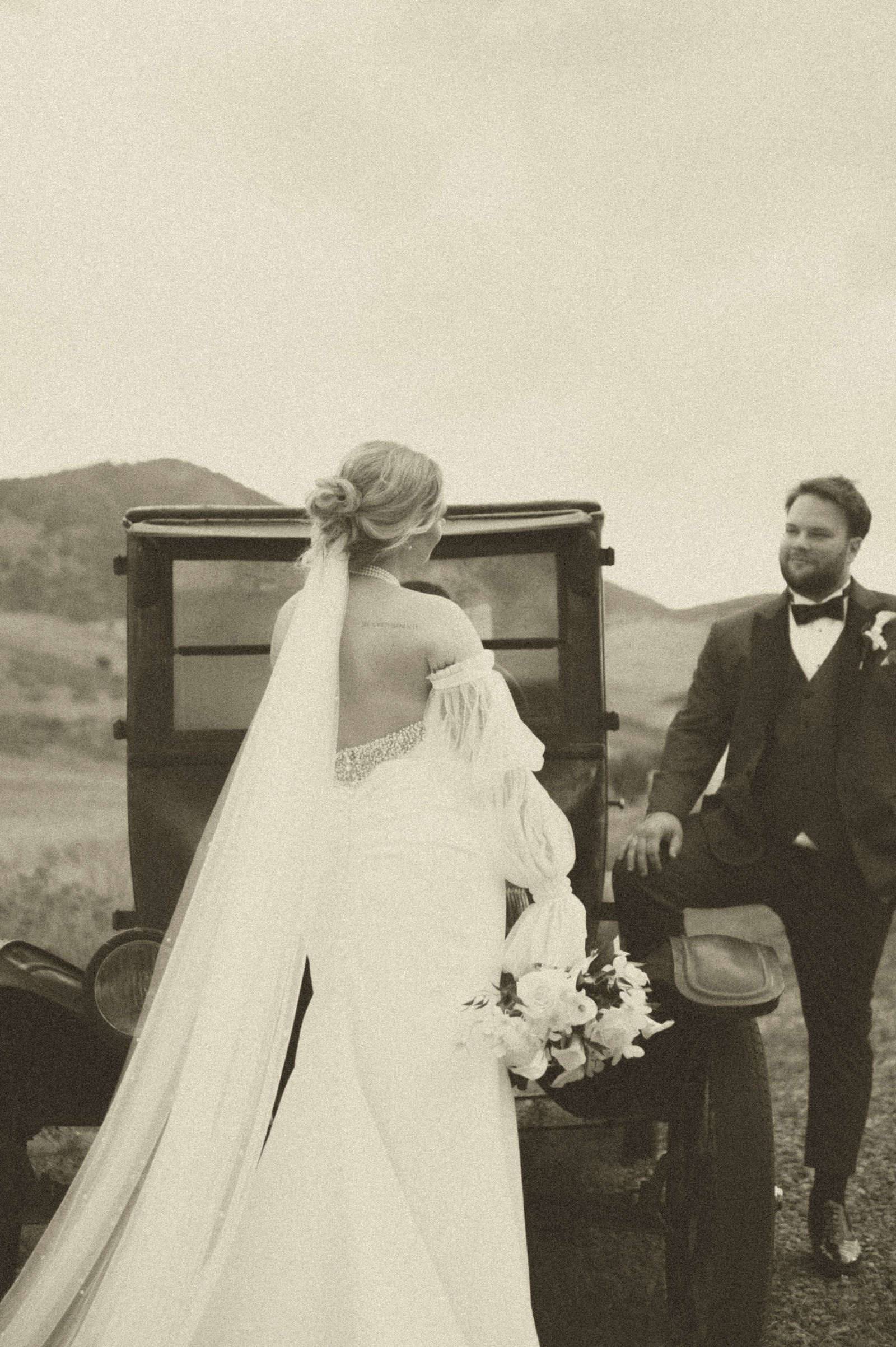 Bride and groom together at the antique car outside The Manor House