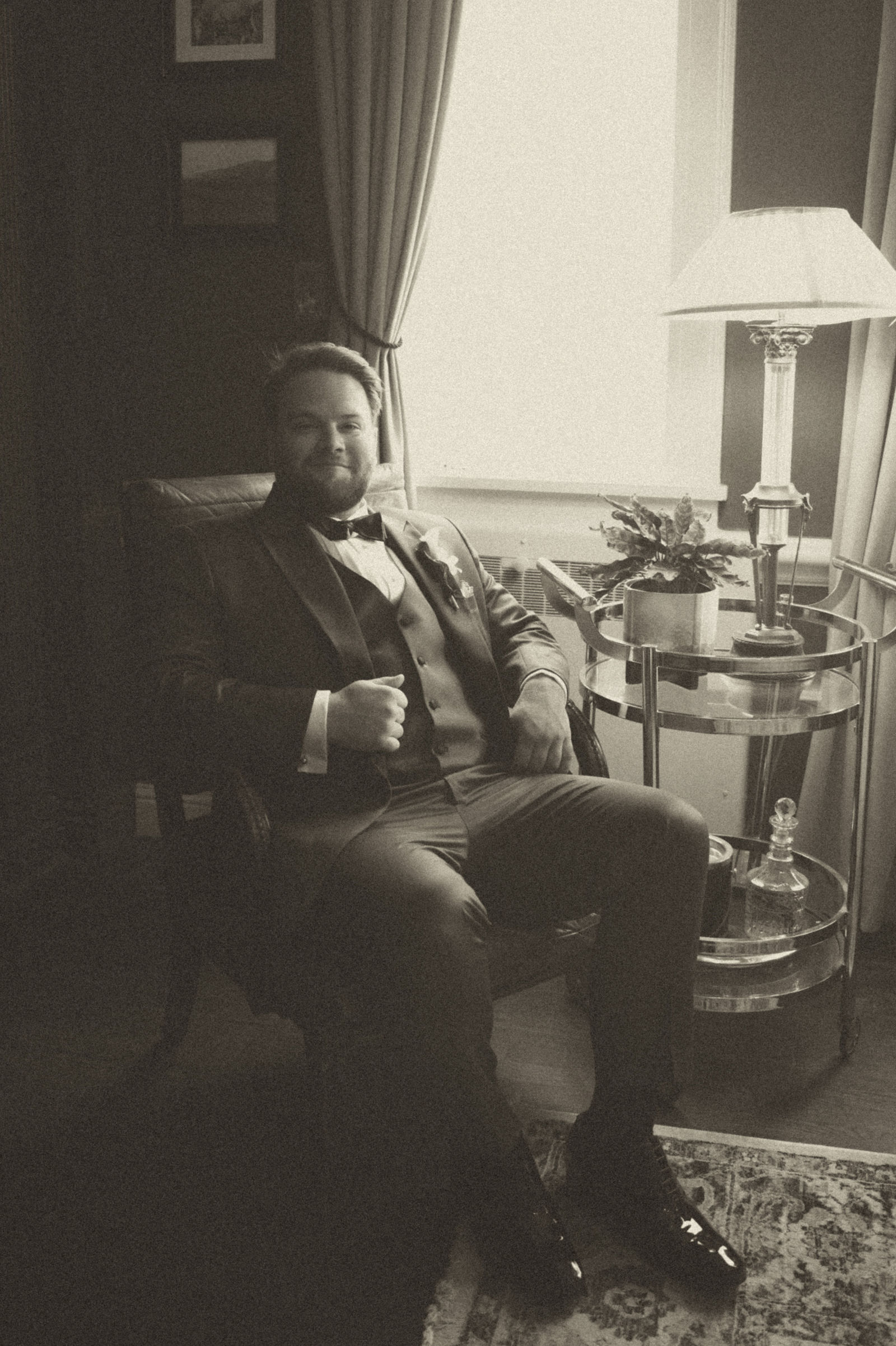 Groom at the bar in the Manor House library in warm sepia tone