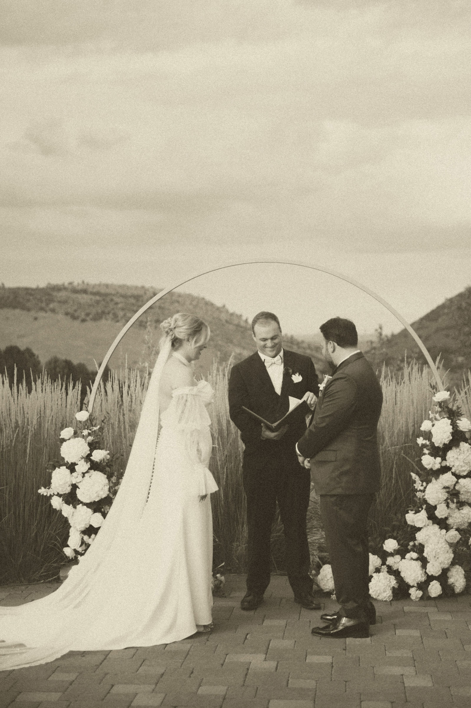 Wide ceremony photo with pampas grass and the Colorado foothills beyond