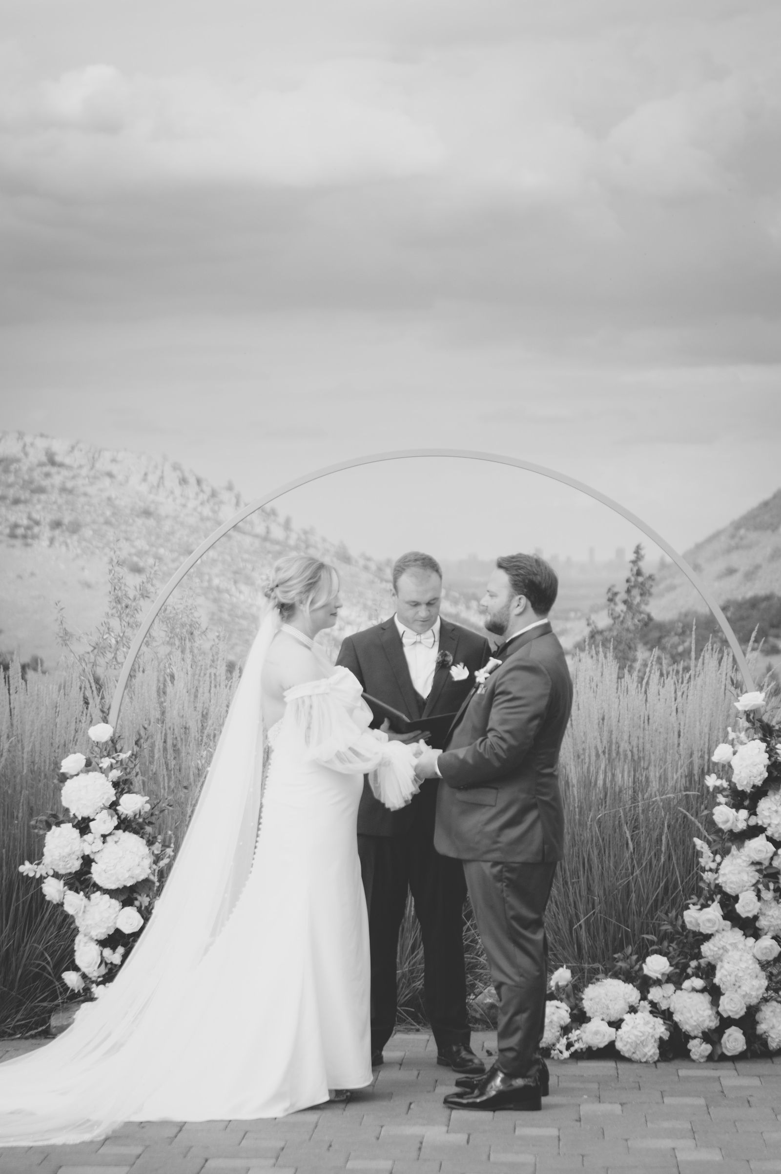 Bride stepping into the circular pampas grass arch at her Colorado wedding