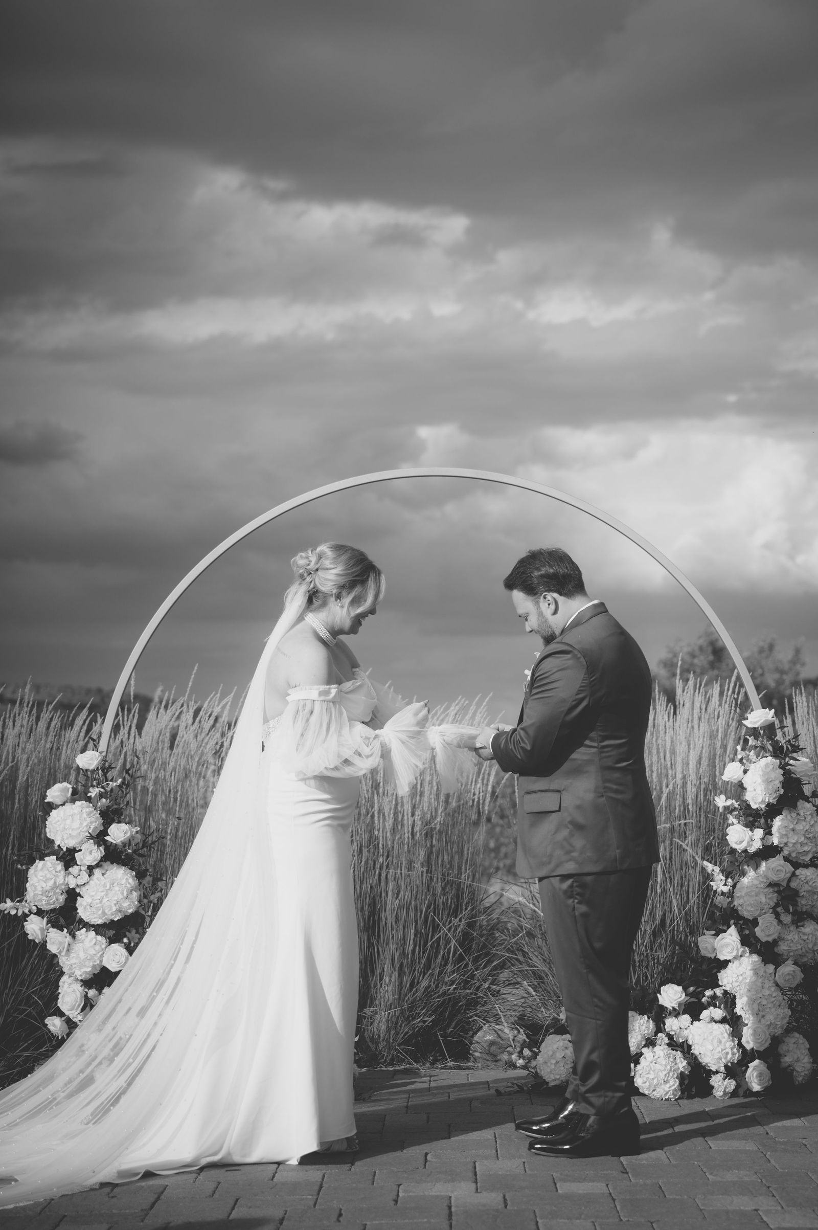 First kiss inside the pampas grass arch at The Manor House Littleton