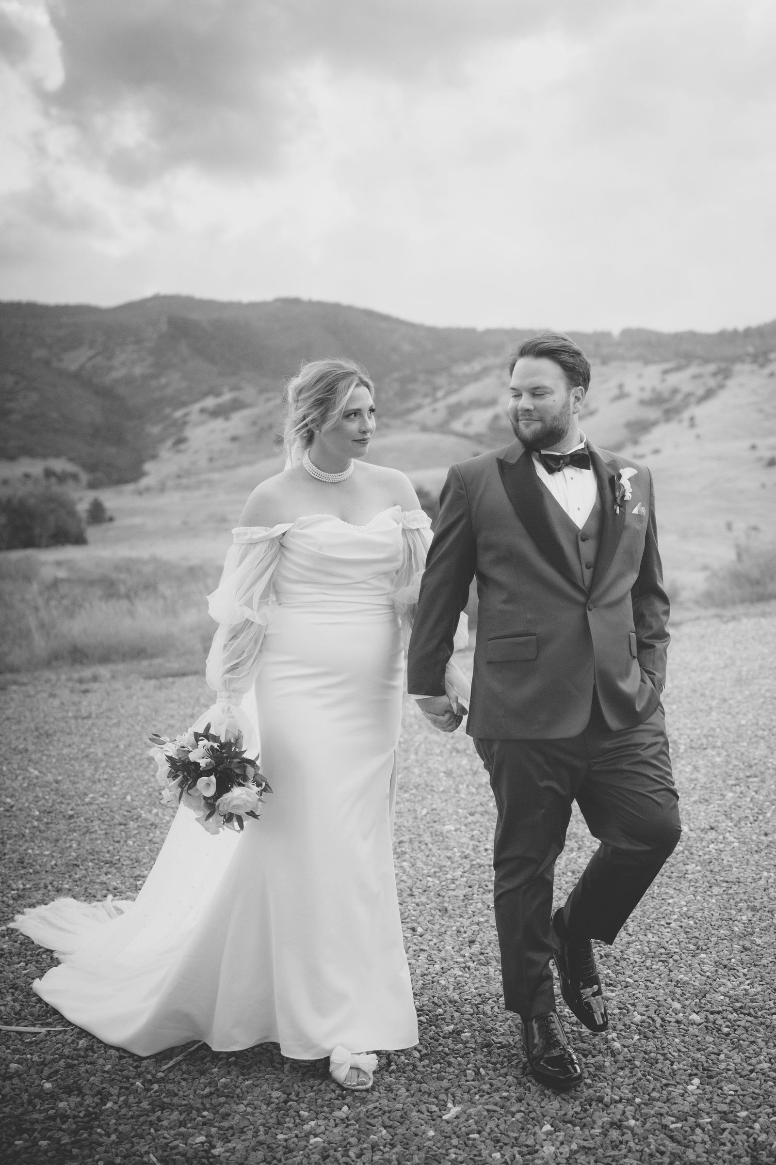 Bride and groom walking with the Front Range behind them in sepia