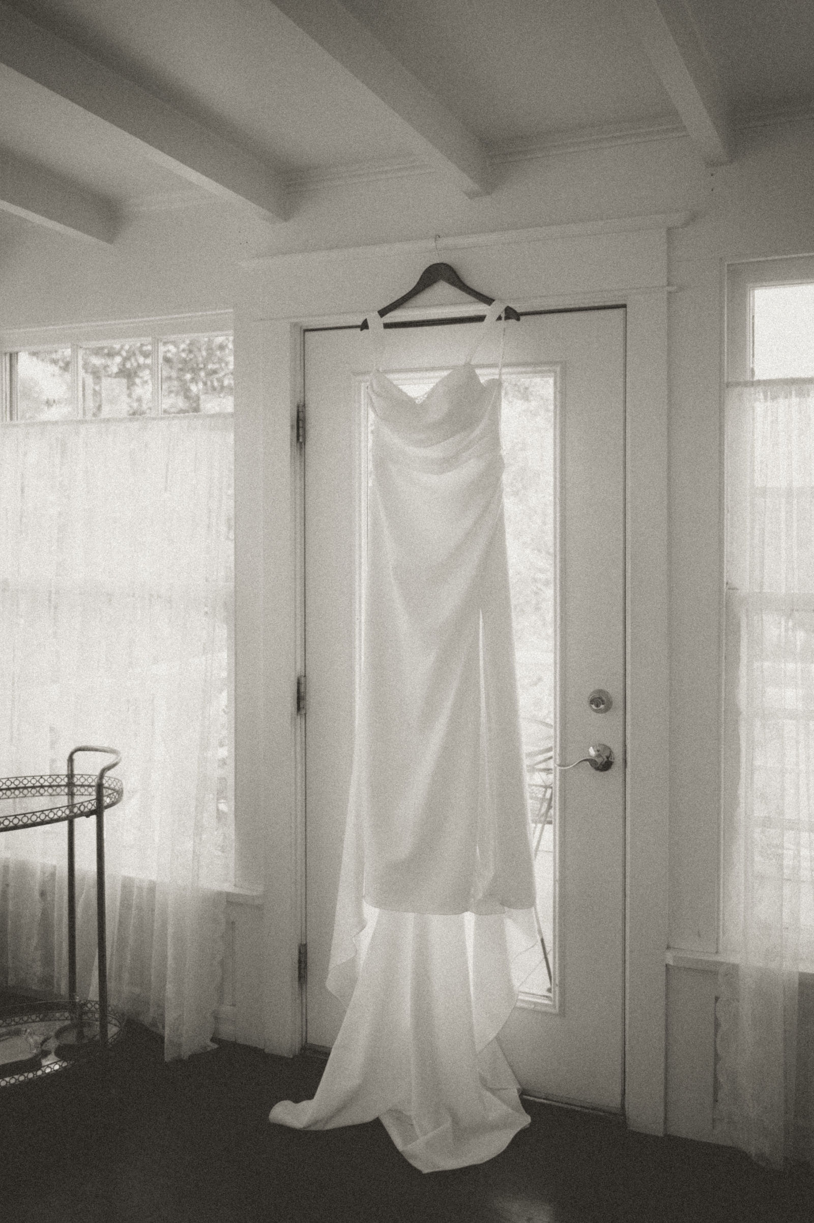 Wedding dress hanging in a doorway at The Manor House edited in vintage sepia tone