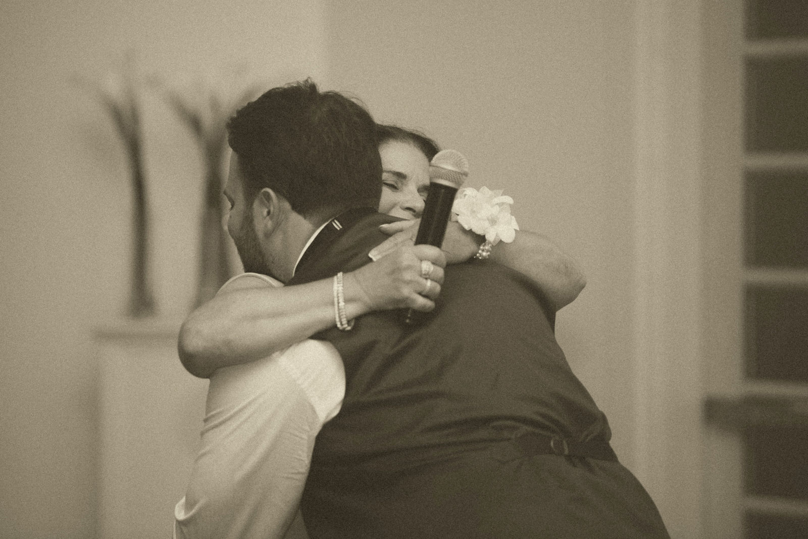 Bride hugging a guest after the toasts in warm sepia tone