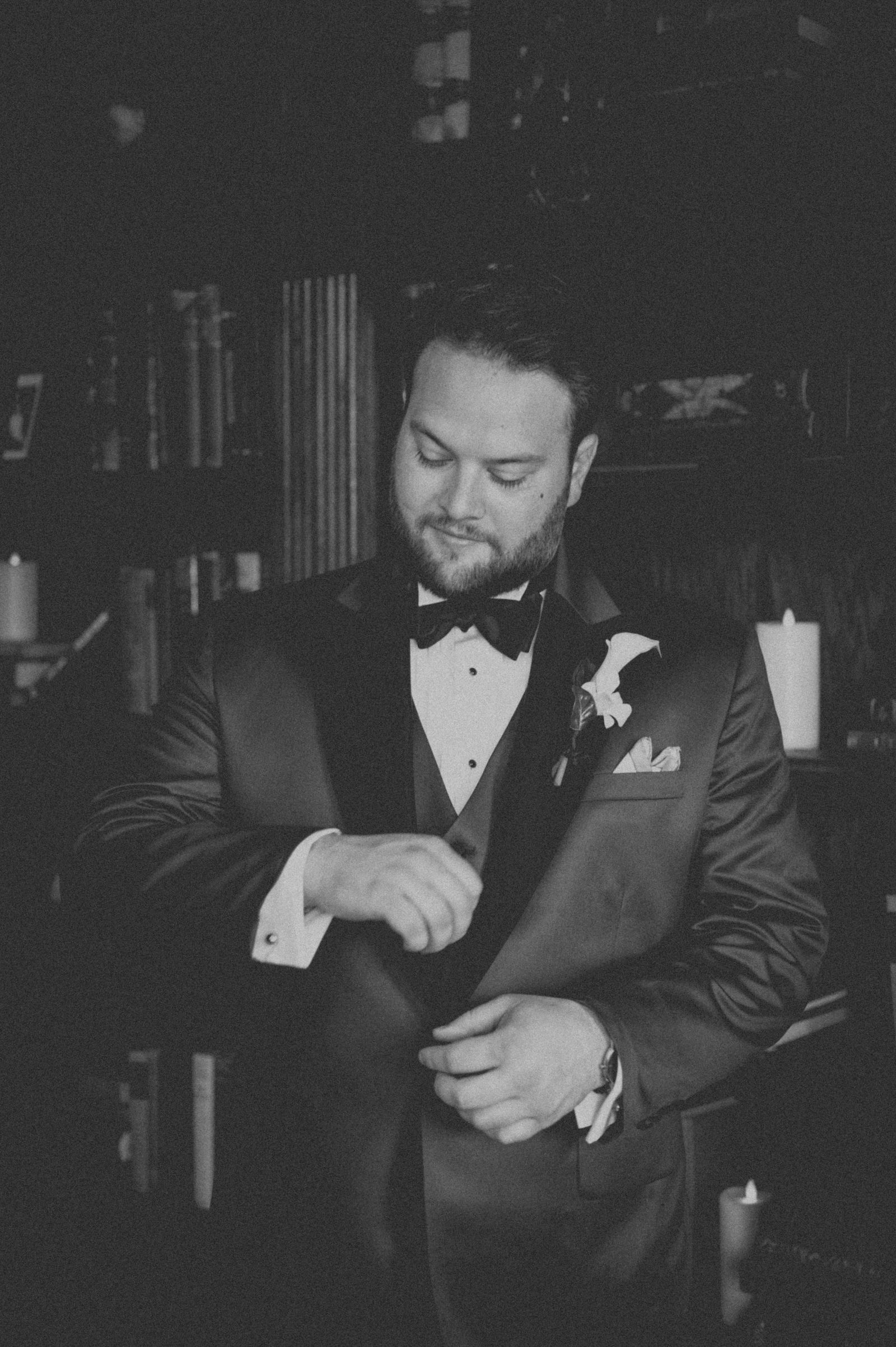 Groom with a drink in the Manor House library styled like a film noir still