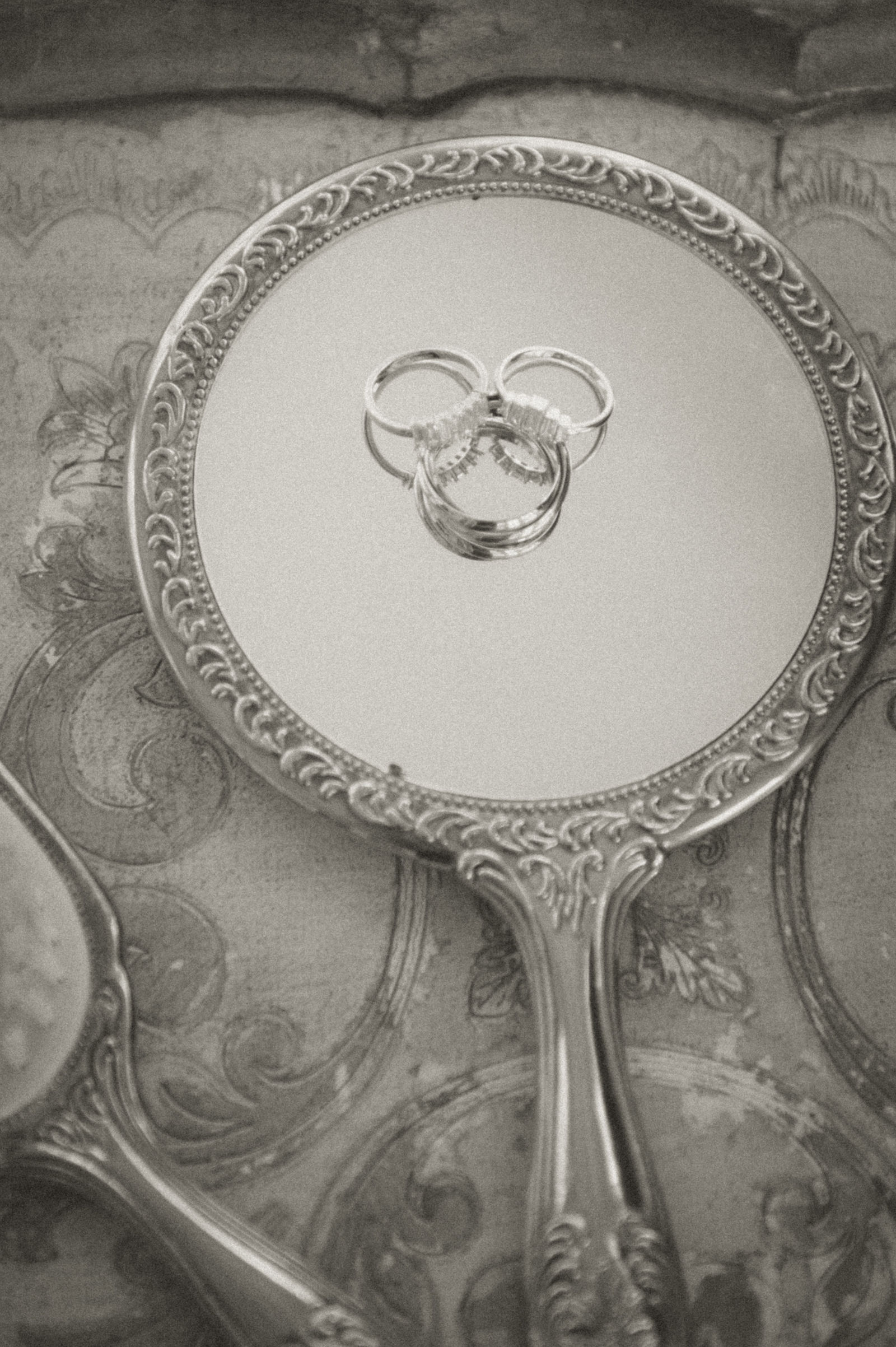 Wedding rings resting on a mirrored tray styled for a 1920s wedding photography look