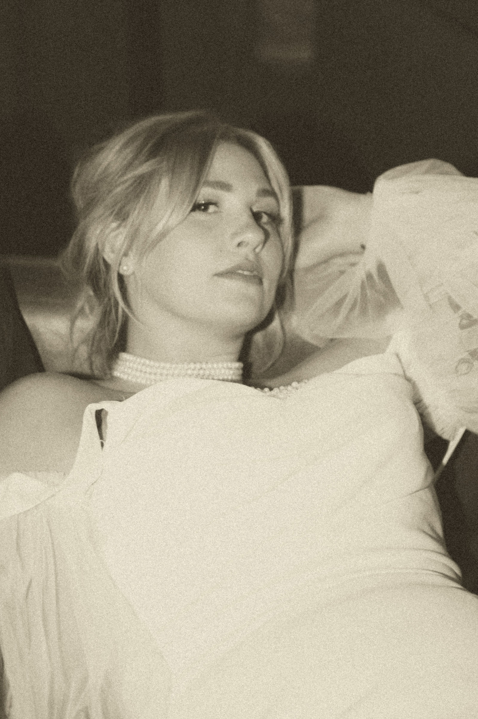 Old Hollywood glamour portrait of the bride reclining in sepia