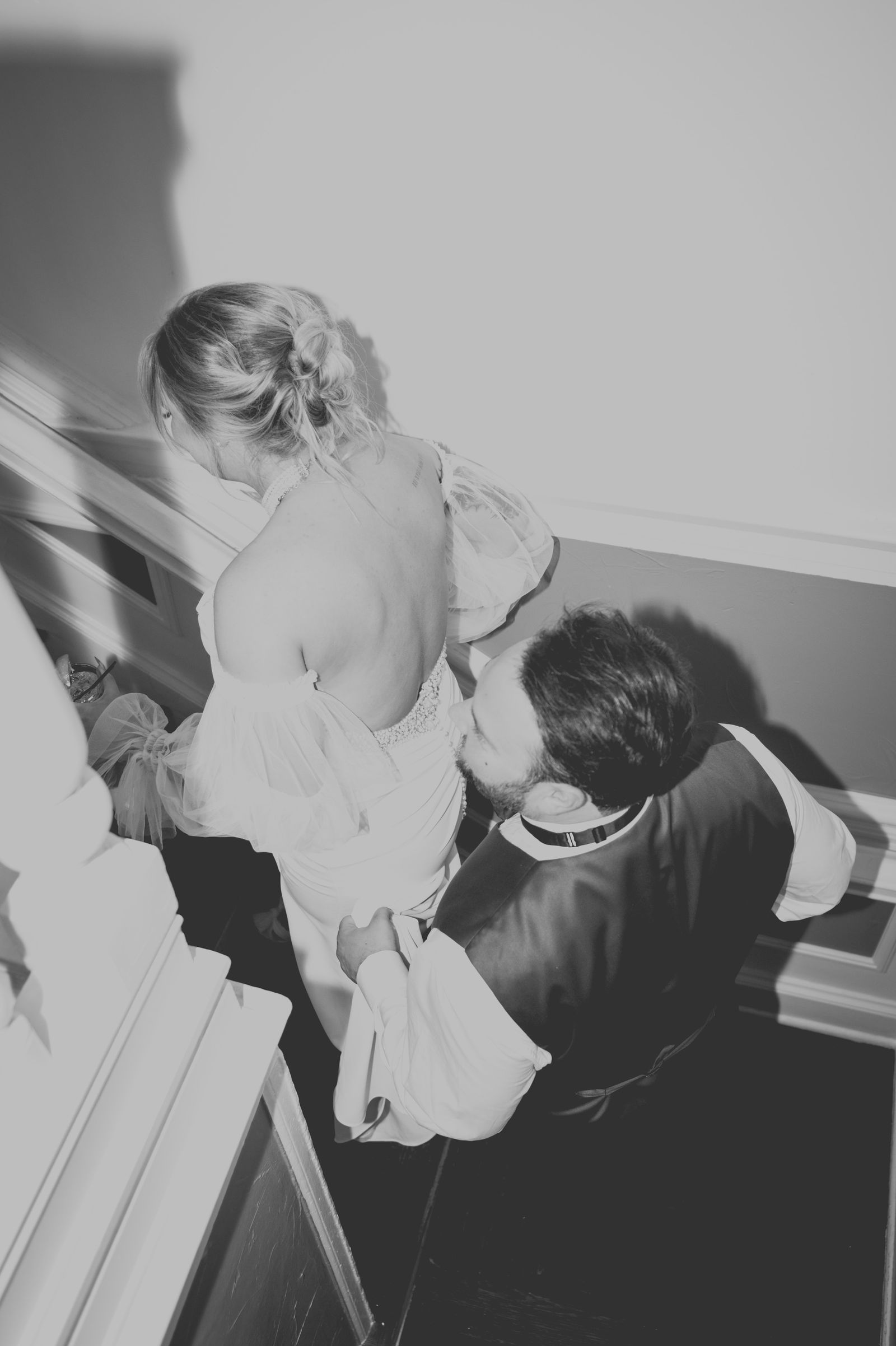 Groom carrying his bride outside The Manor House in Littleton