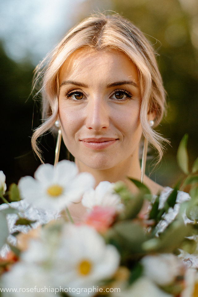 Portrait de la mariée derrière son bouquet