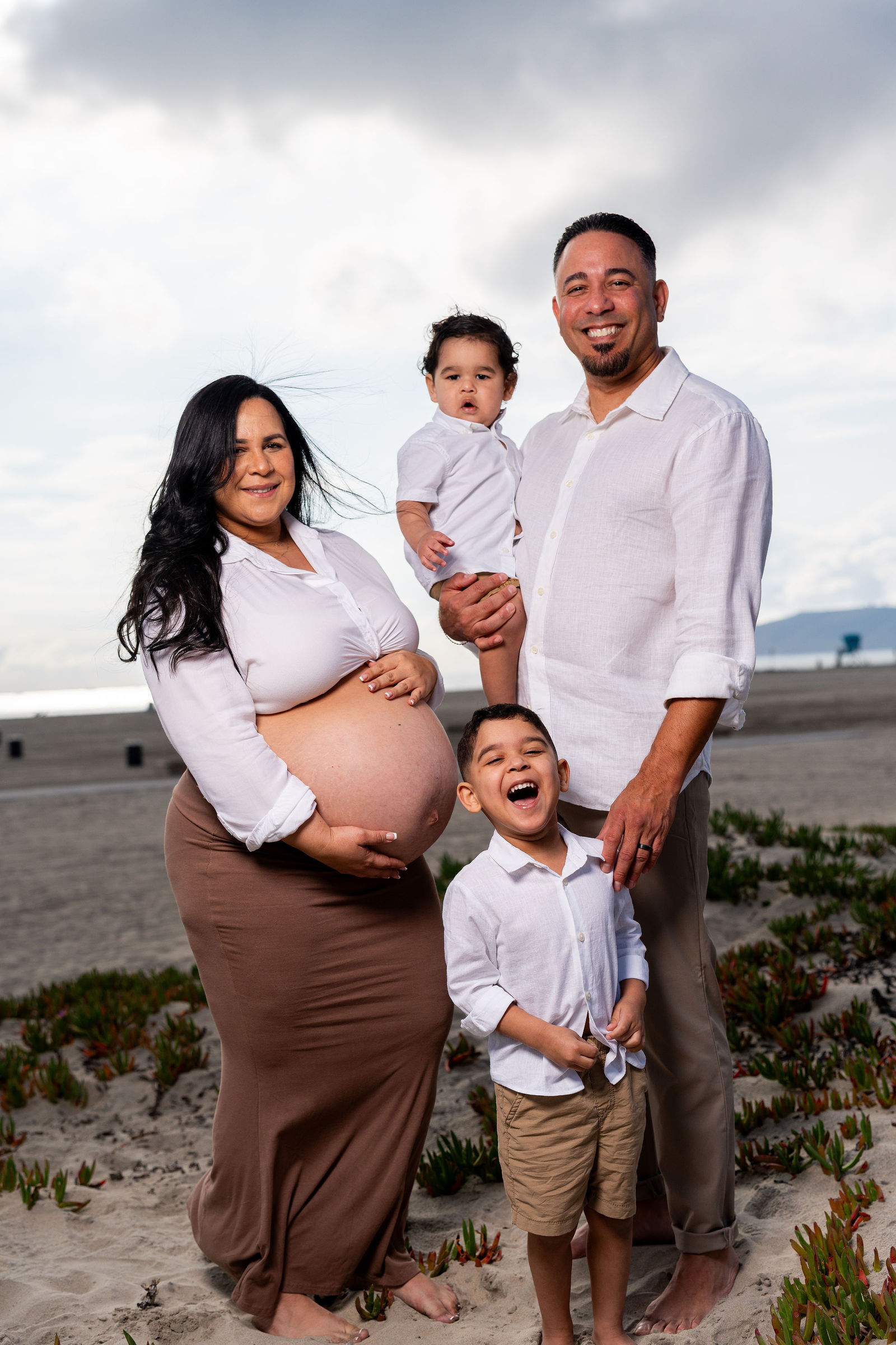 Four generations of one family laughing together at a San Diego milestone celebration
