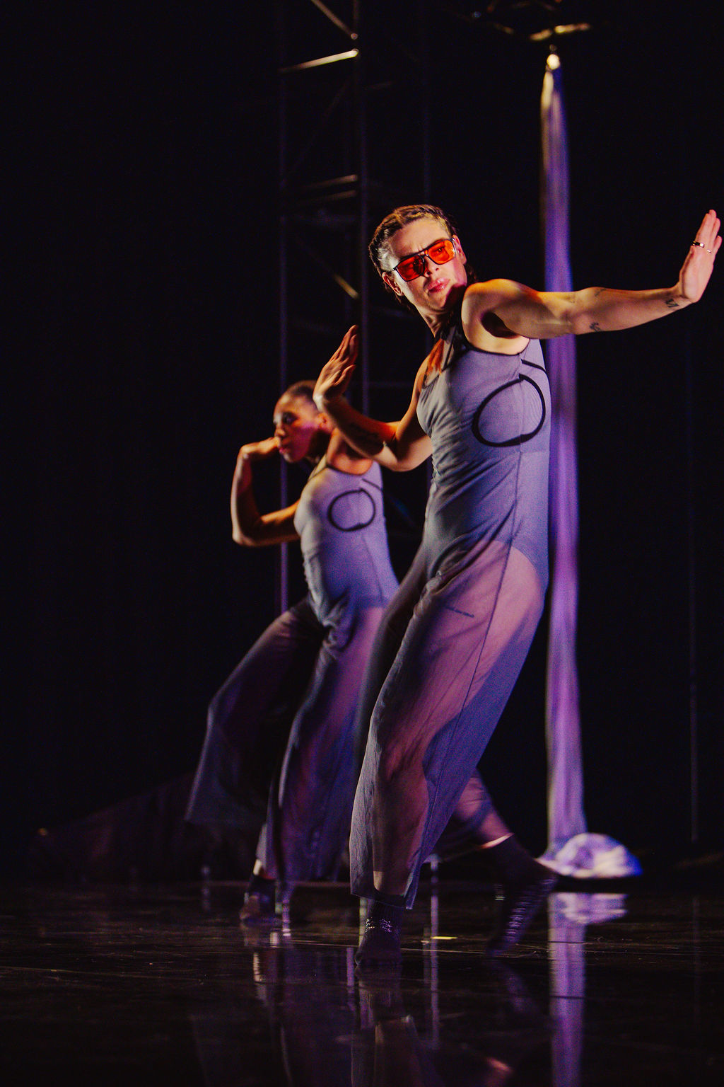 Event photography company capturing a dancer mid-movement under dramatic purple stage lighting