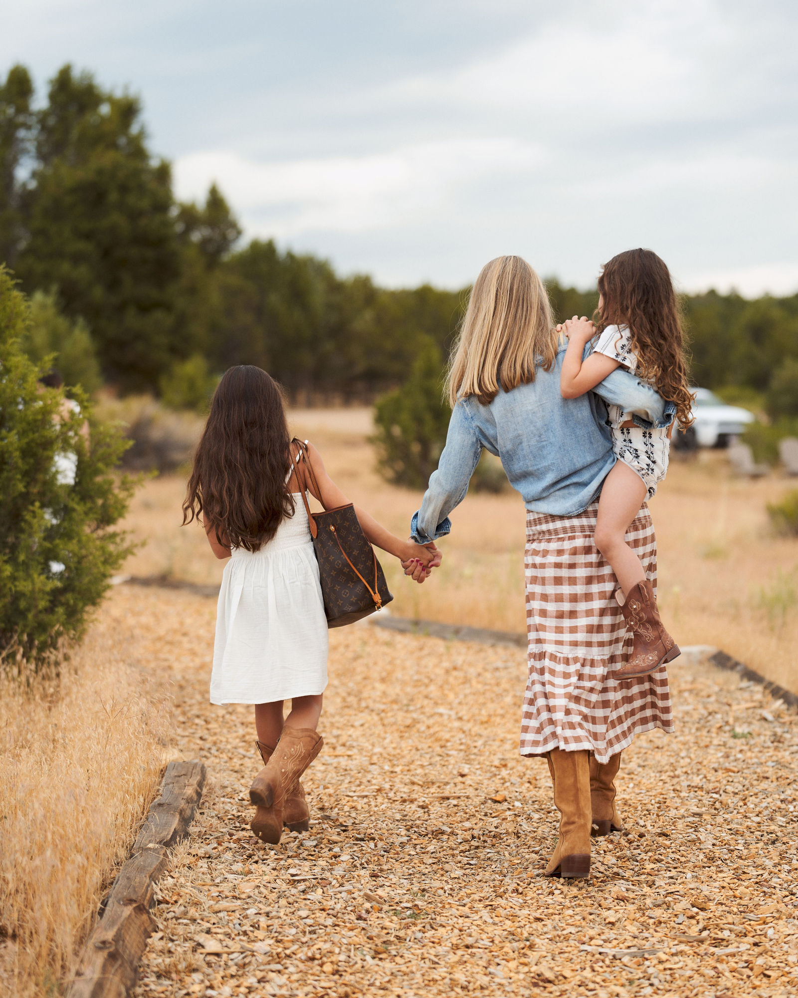 Grandmother and granddaughter holding hands while walking down a trail