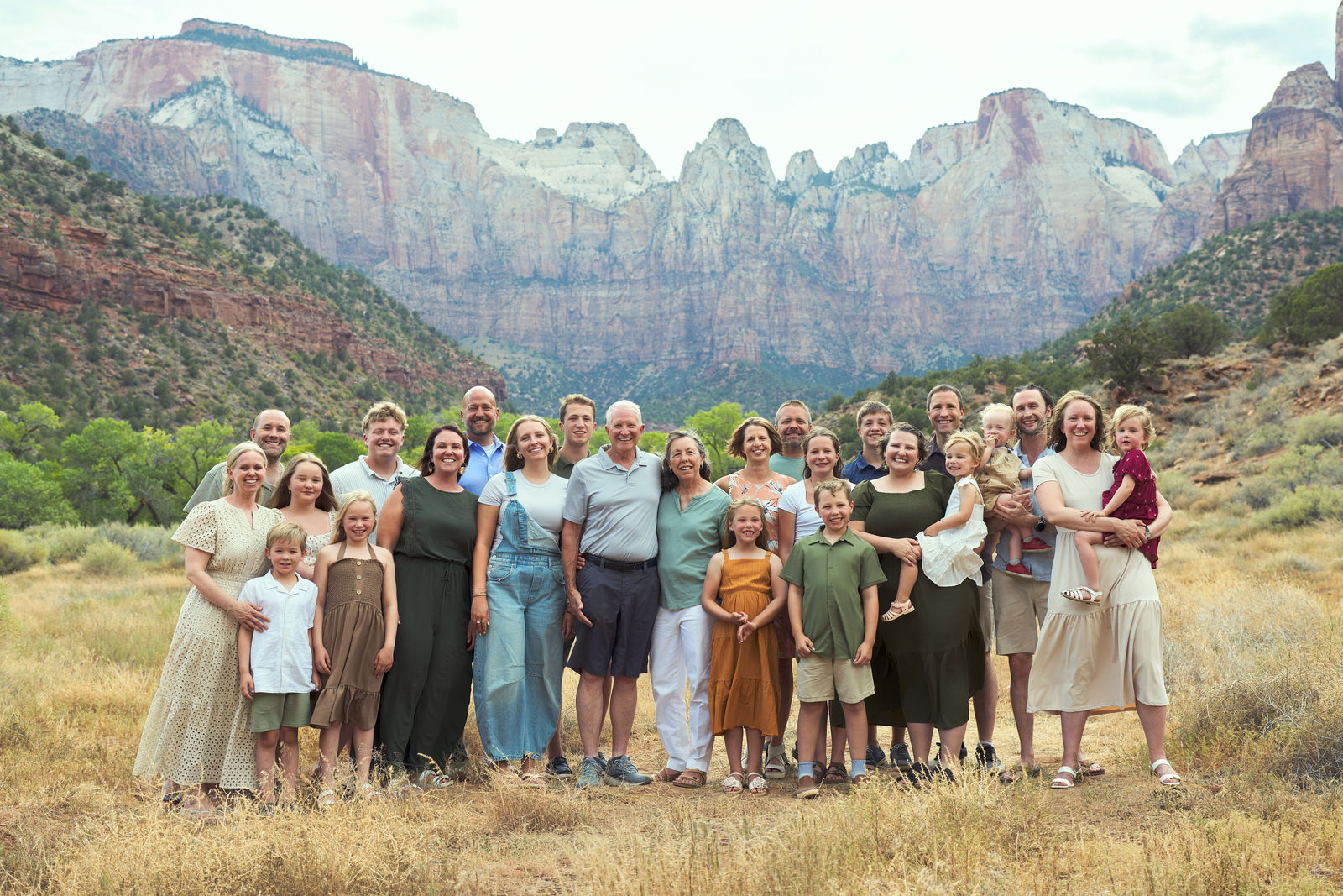 Extended family gathered for a group portrait with the Zion landscape behind them