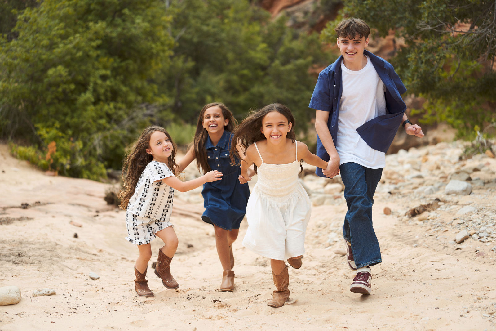 Children from an extended family running through the sand and laughing together
