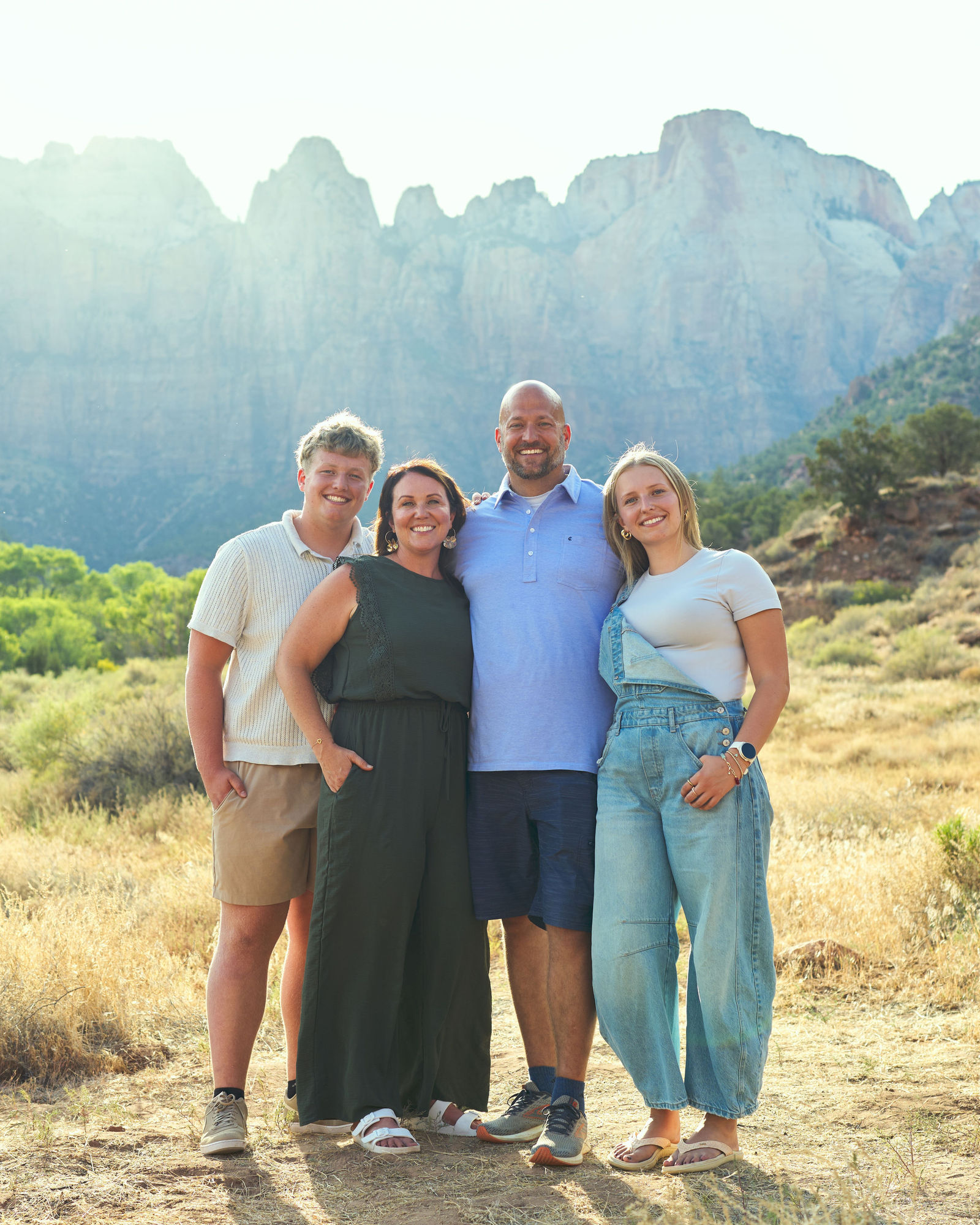 Family of four standing together and smiling for a relaxed portrait