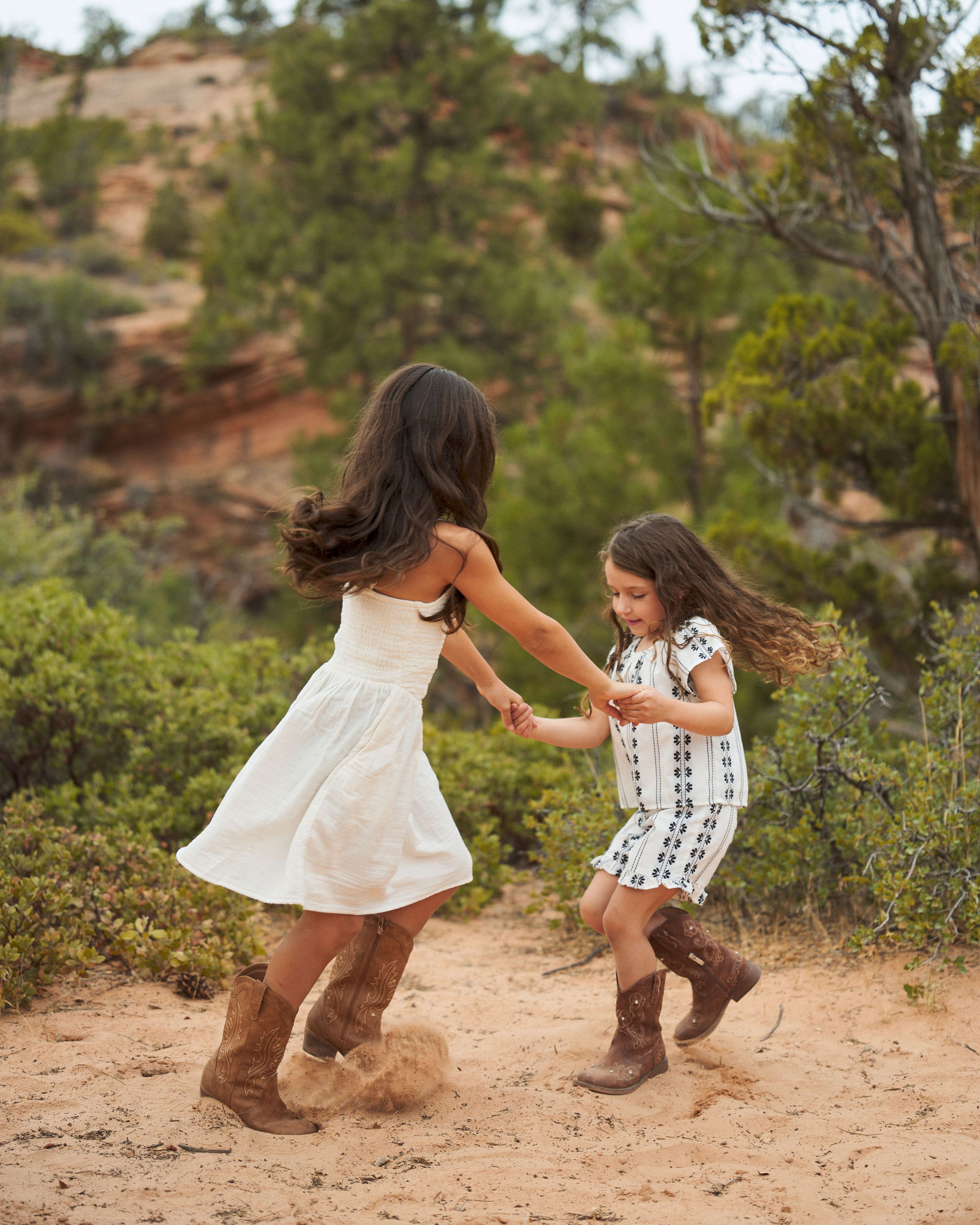 Two sisters spinning and dancing together during their family session