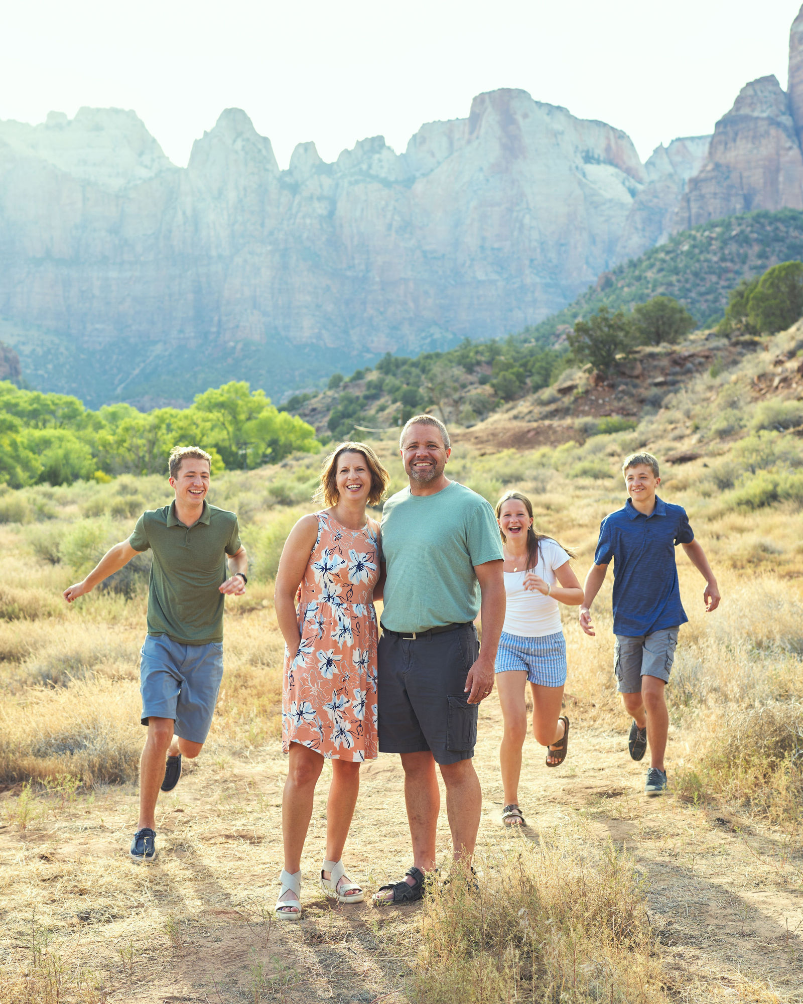 Children running toward their smiling parents during an extended family session