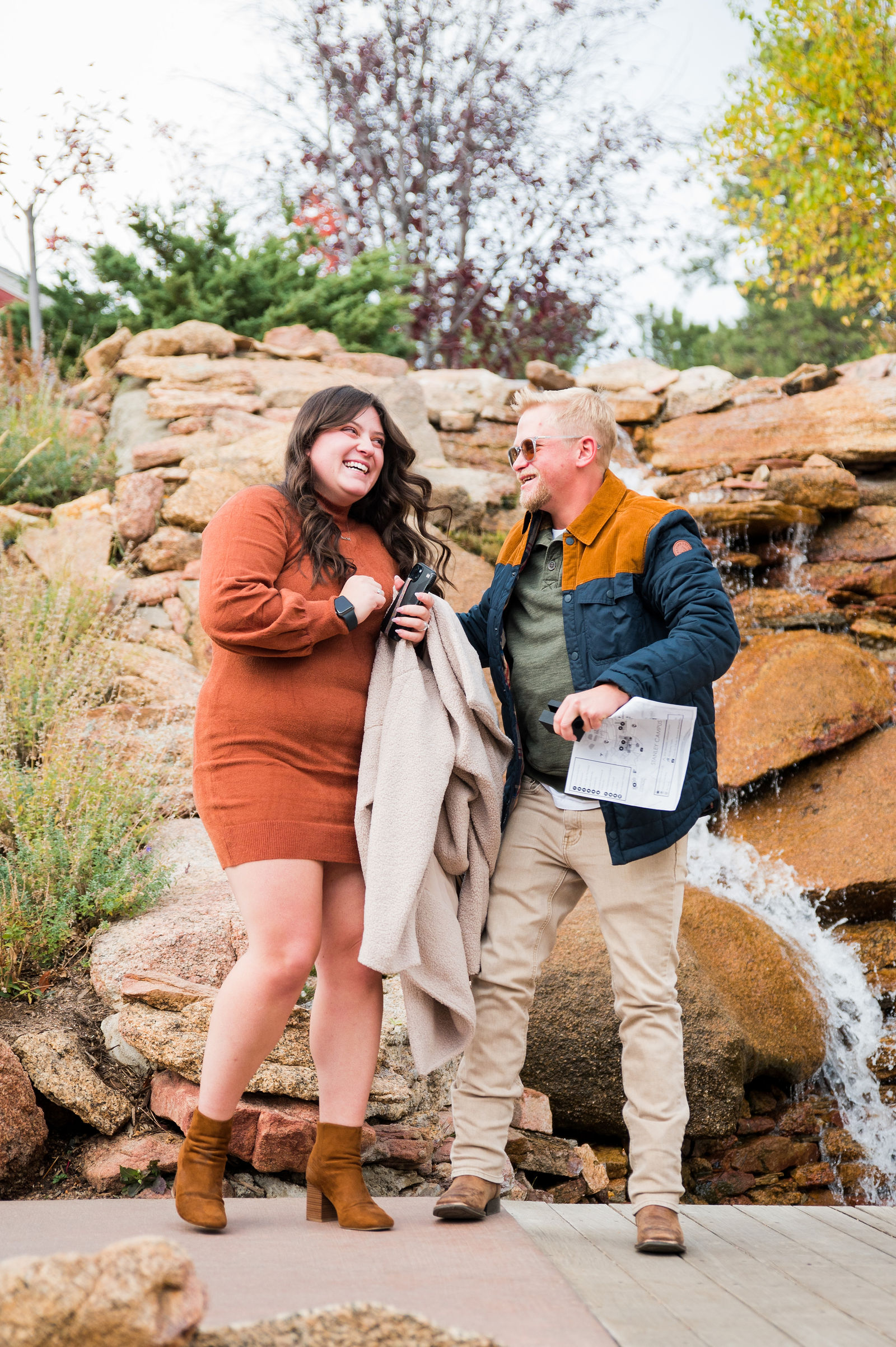 Engaged couple with the woman in a rust knit sweater dress and brown boots on an October day in Colorado