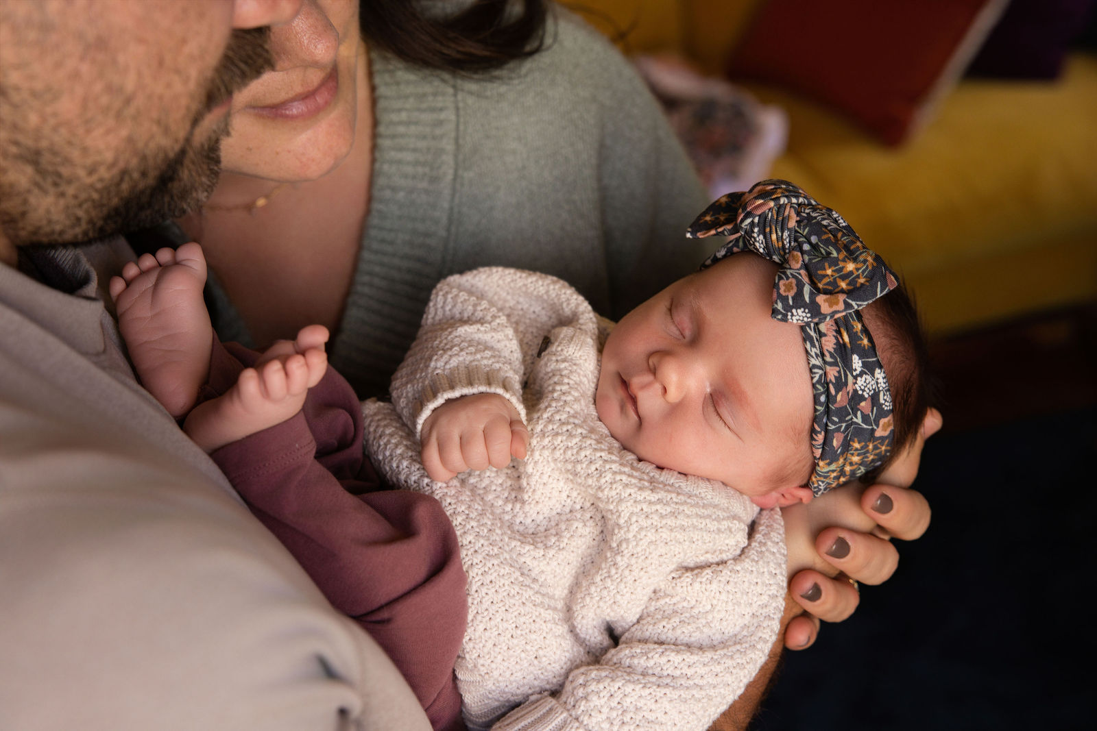 Utah County in-home newborn photography with parents cuddling baby near a bright window