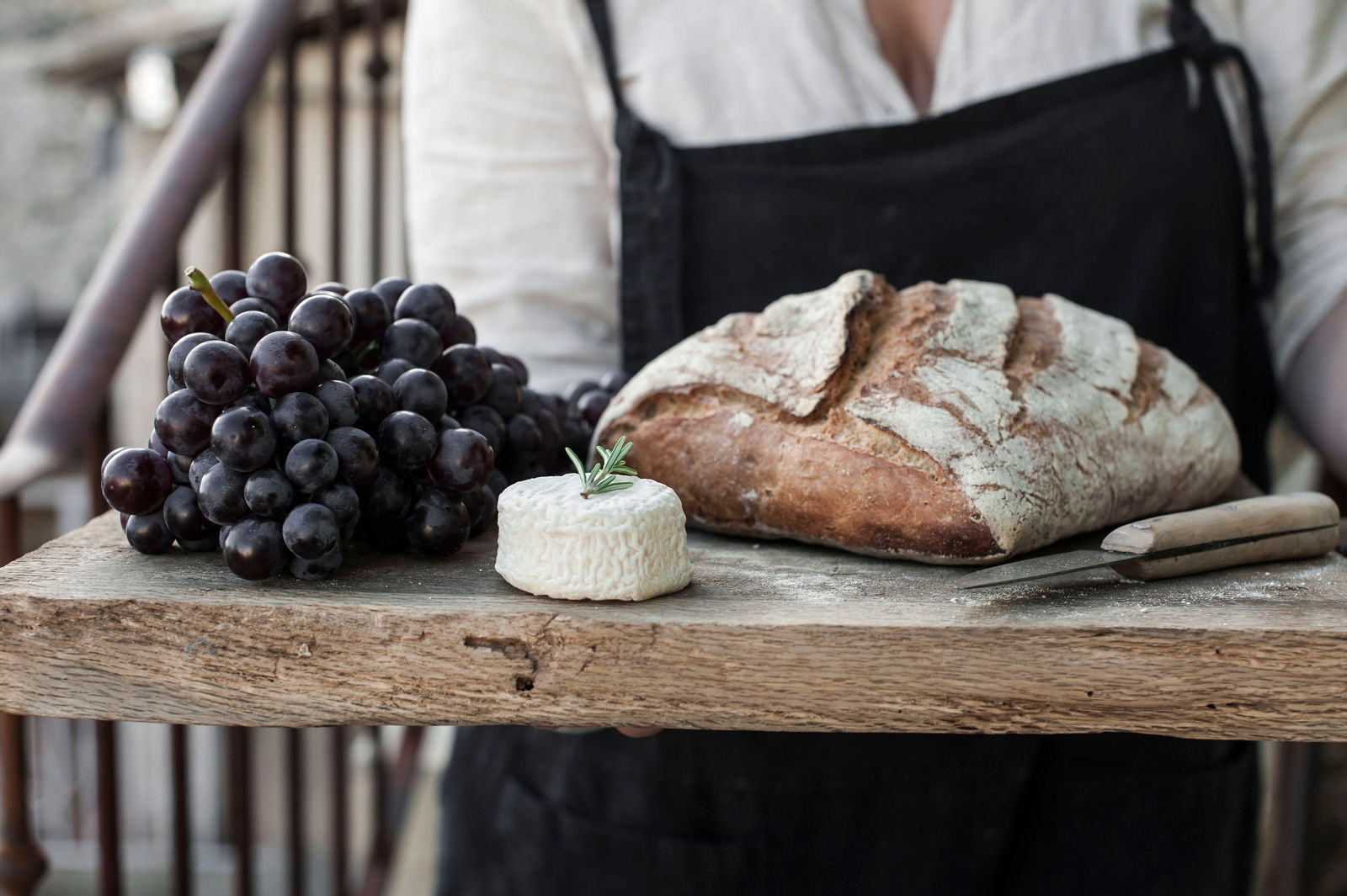 Grapes, cheese and sourdough closeup on a wooden board