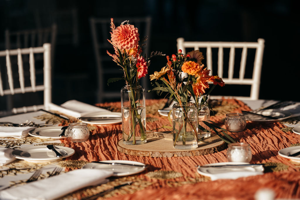 Reception table with rust linens and bud vases