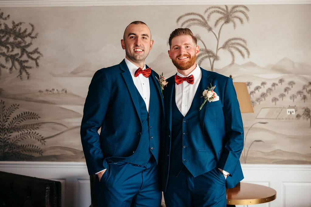 Groomsmen in navy suits with red bow ties
