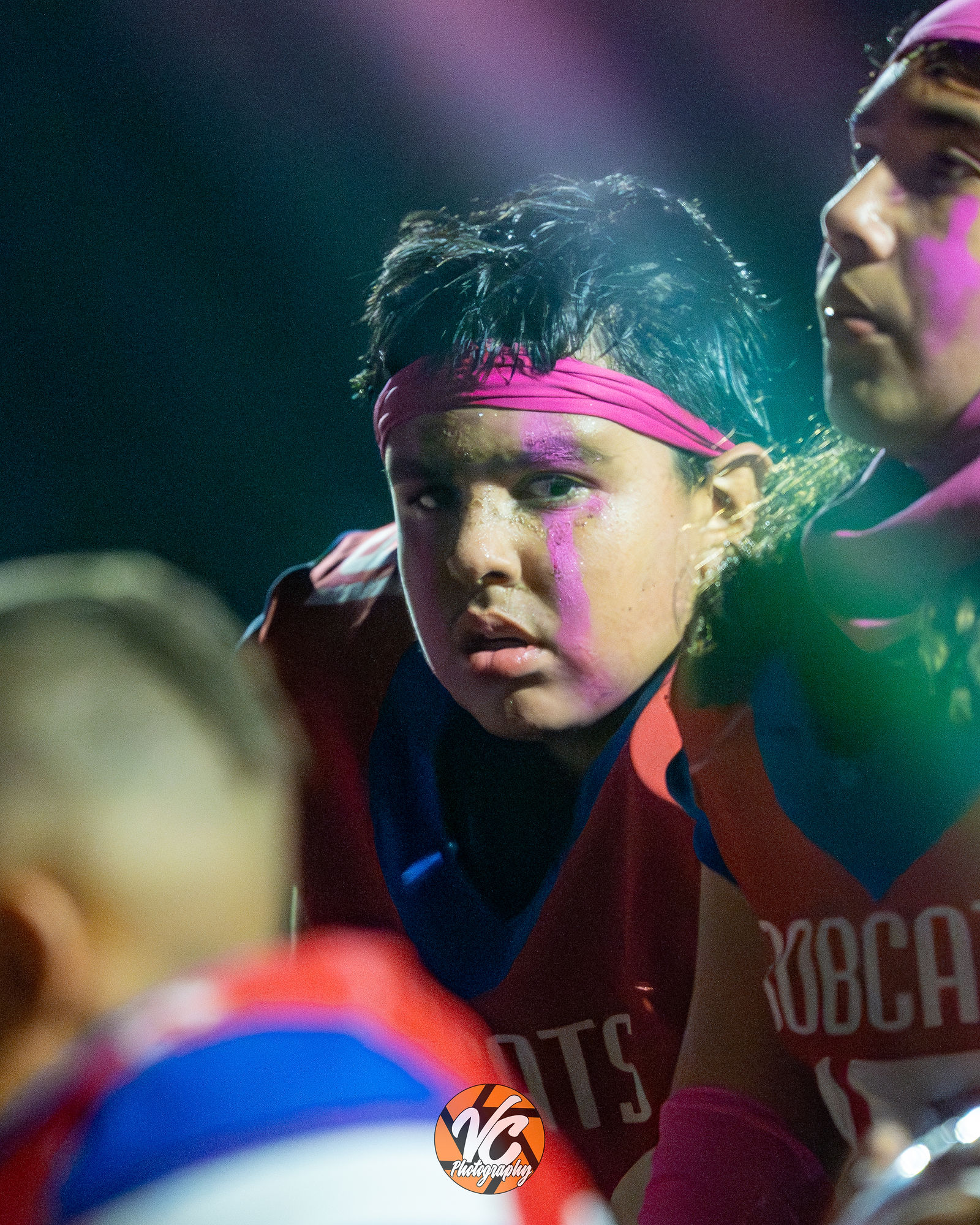 Barton Bobcats offensive line engaging Dahlstrom defenders during middle school football action under the lights