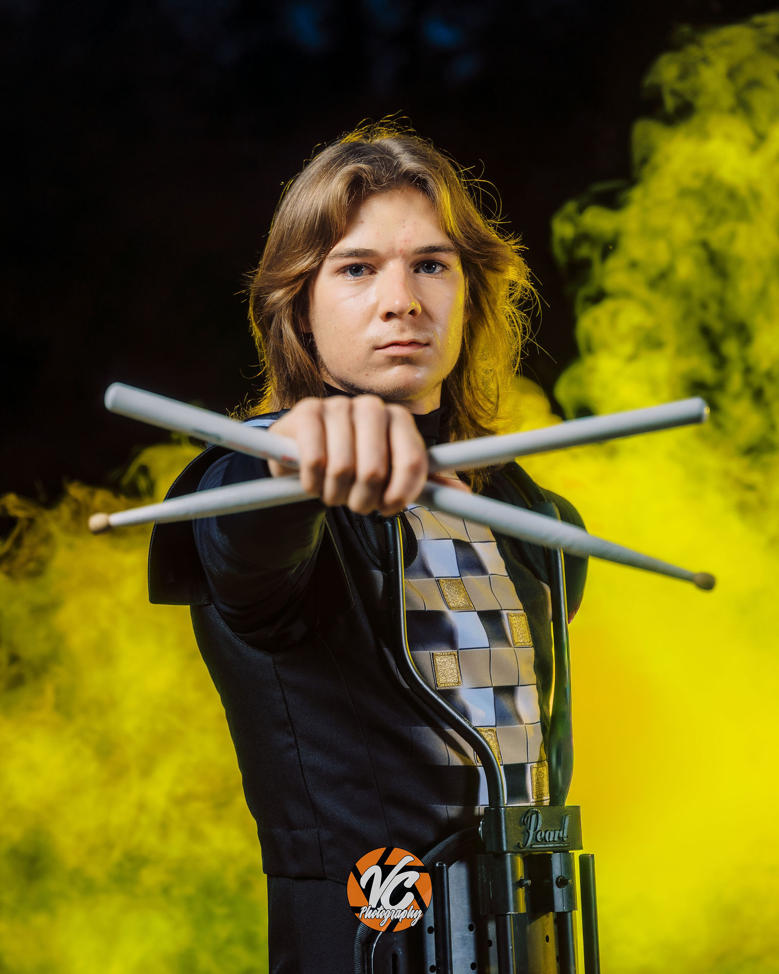 Johnson High School drummer Chase Urbanovsky posing with drumsticks during a dramatic backyard portrait session in Buda Texas