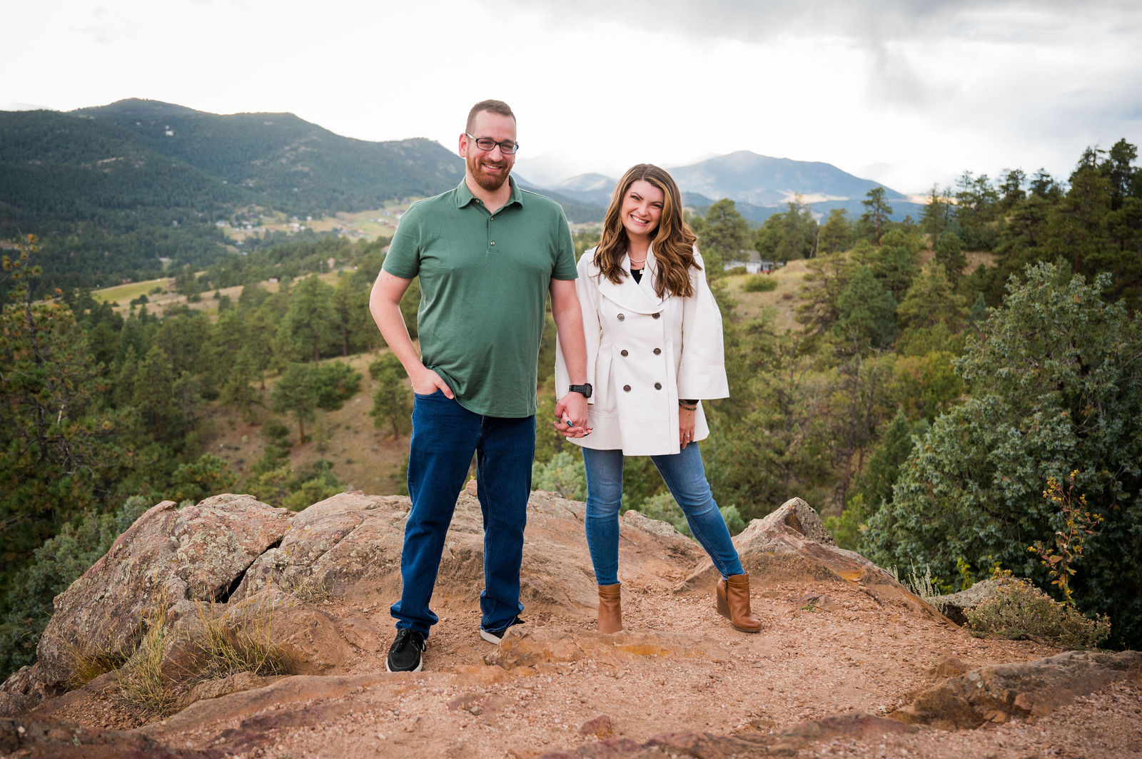 Engaged couple in a forest green polo and a cream shirt jacket in the Colorado foothills in September